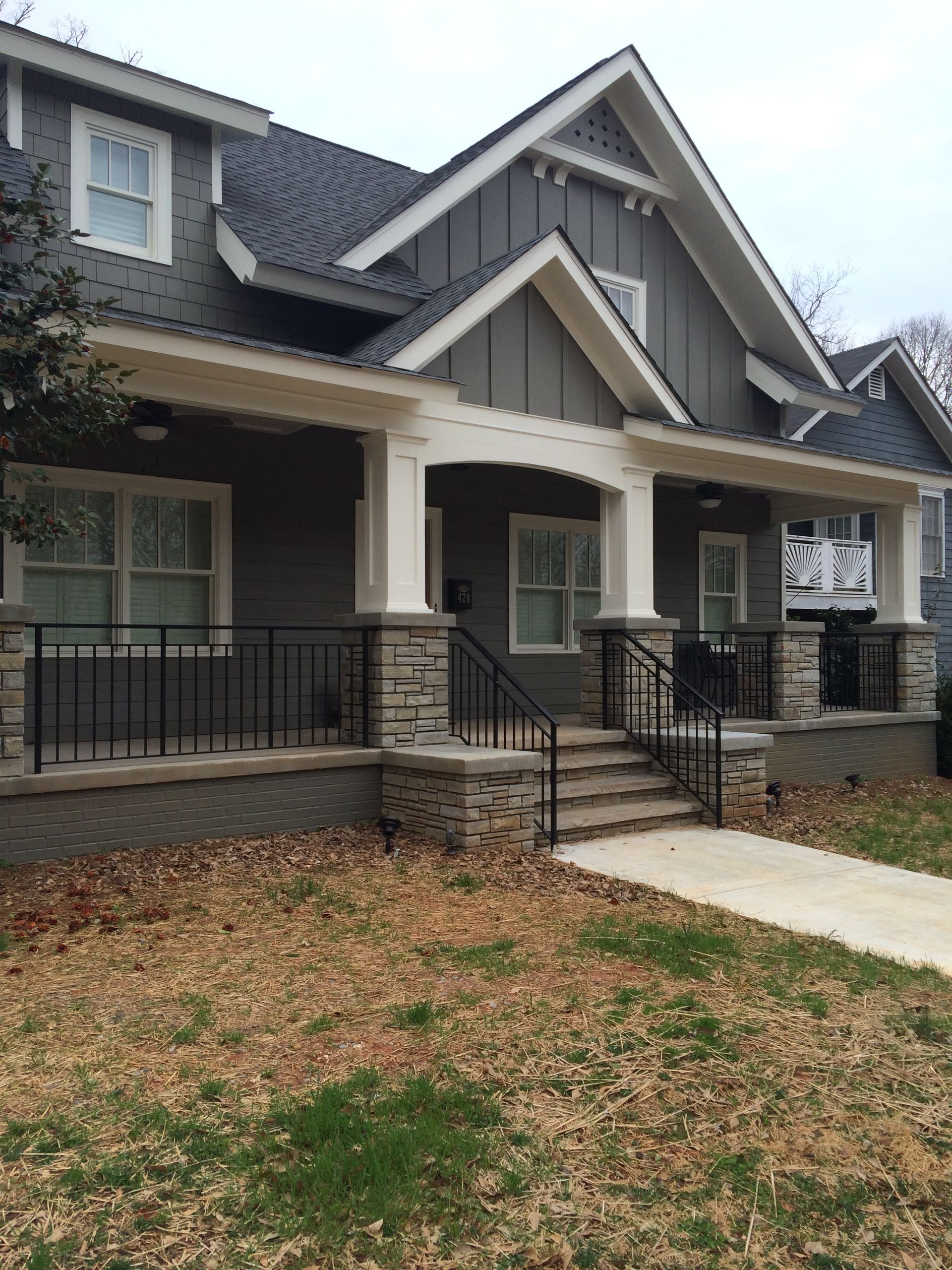 A large gray house with a porch and stairs