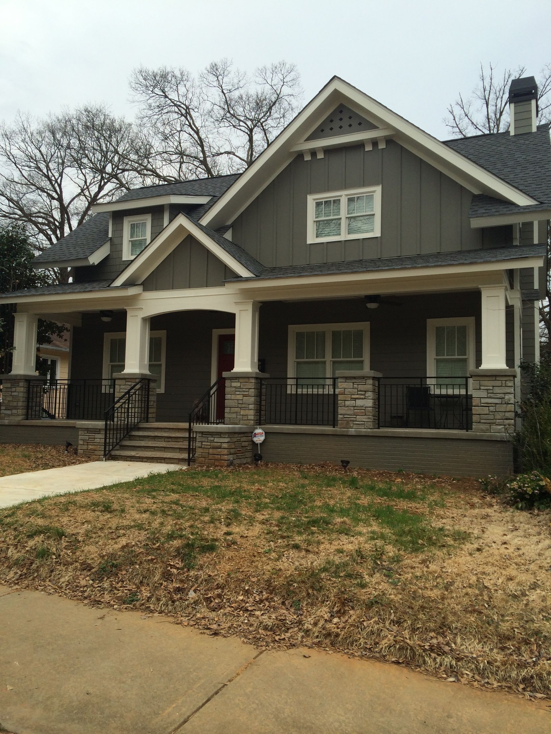A house with a large porch and a gray roof