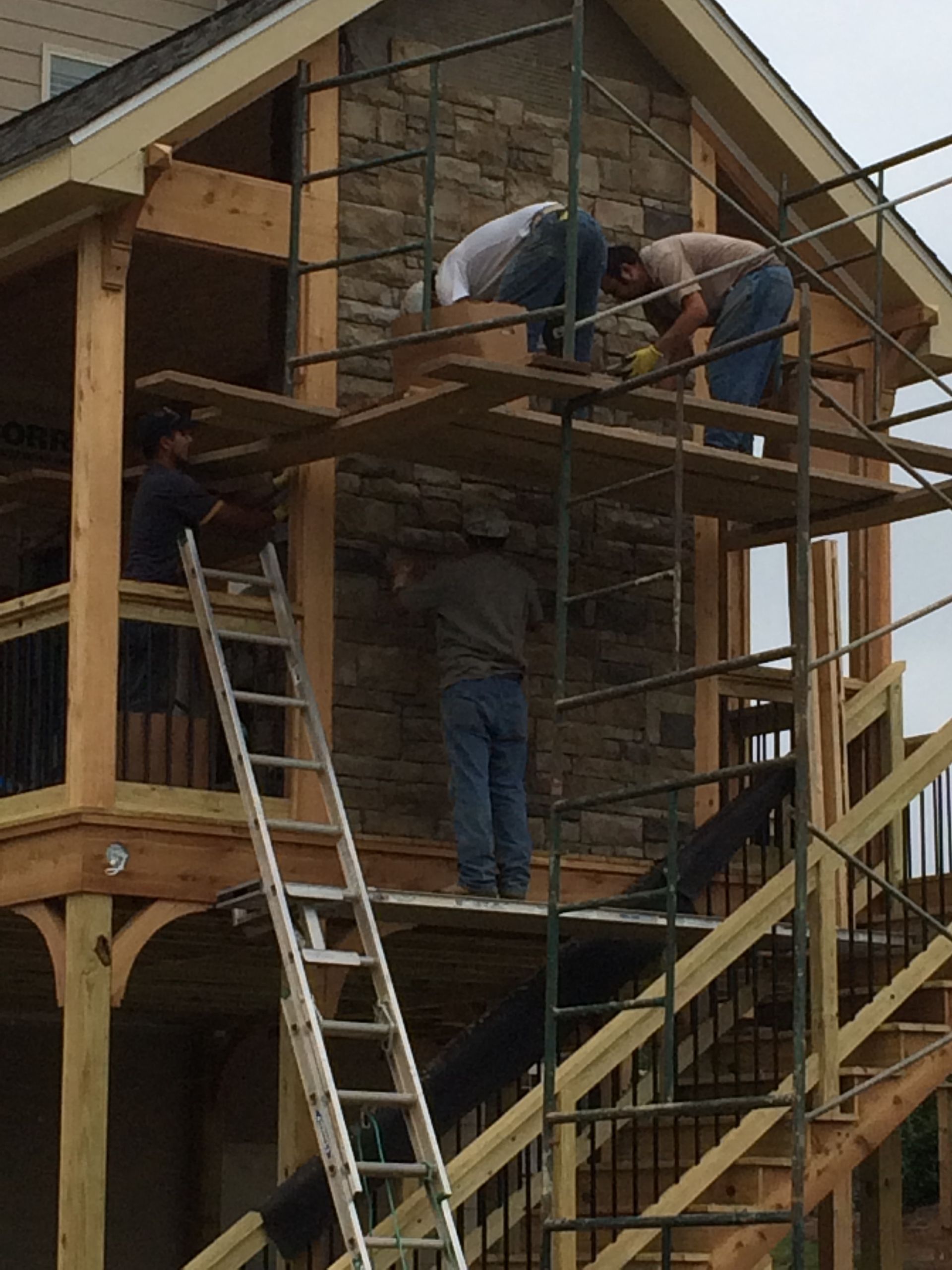 A group of men are working on a house with scaffolding