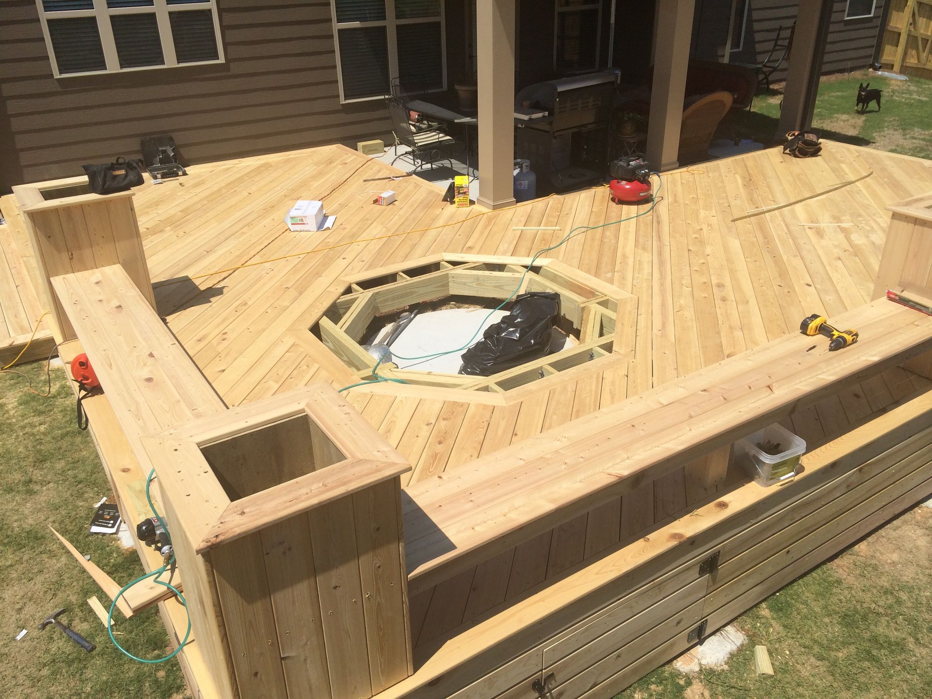 A wooden deck is being built with a hot tub in the middle.