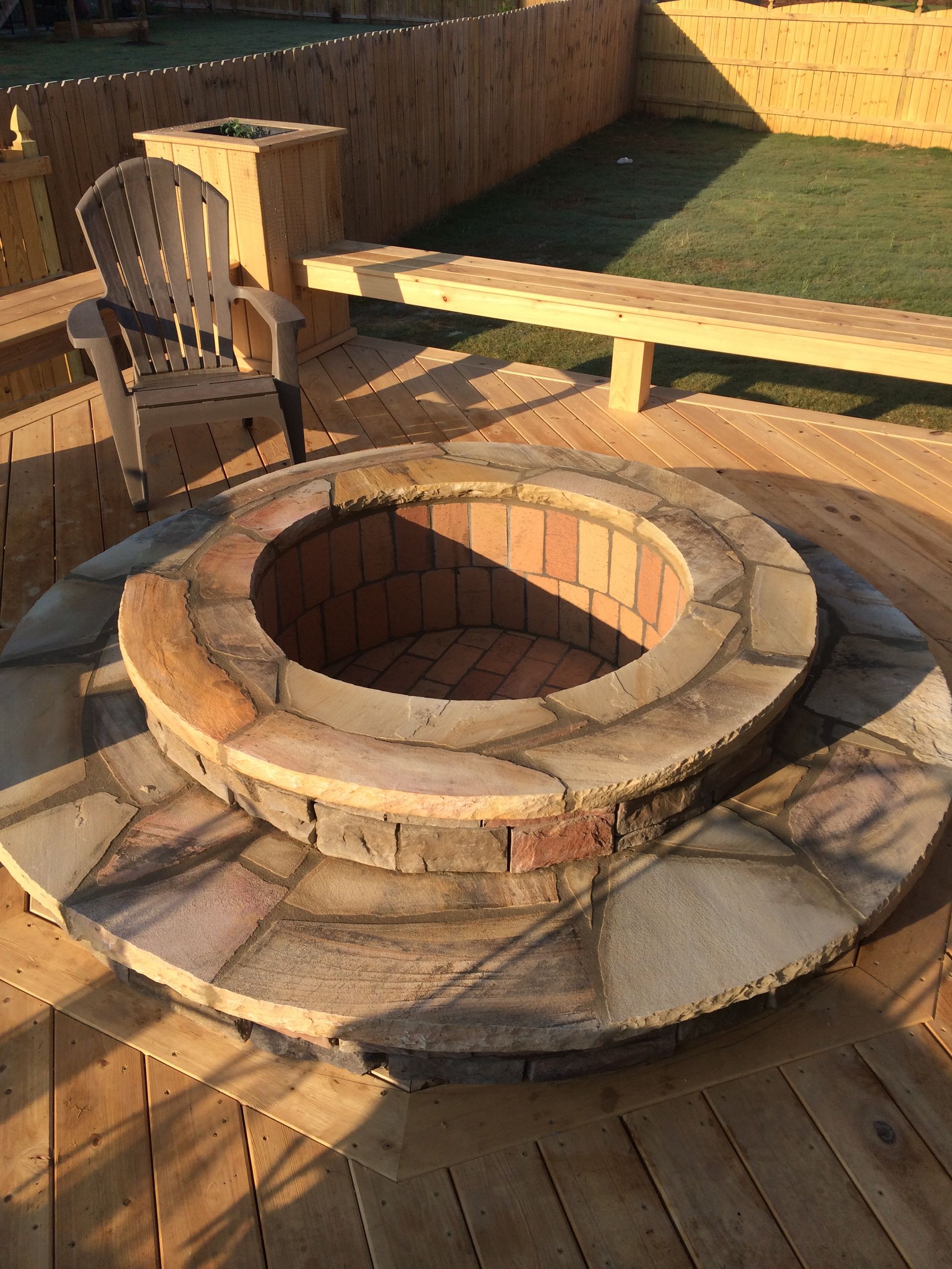 A fire pit is sitting on top of a wooden deck.