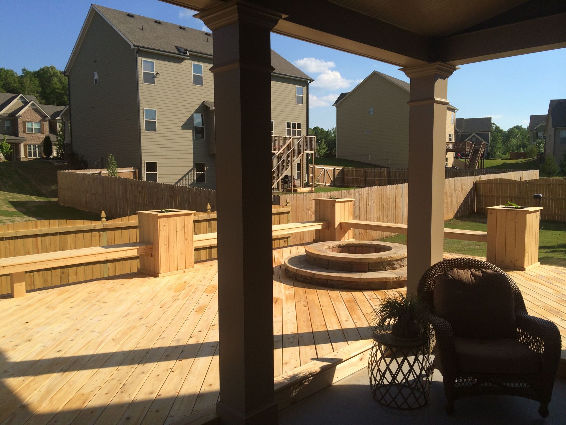 A wooden deck with a fire pit in the middle of it