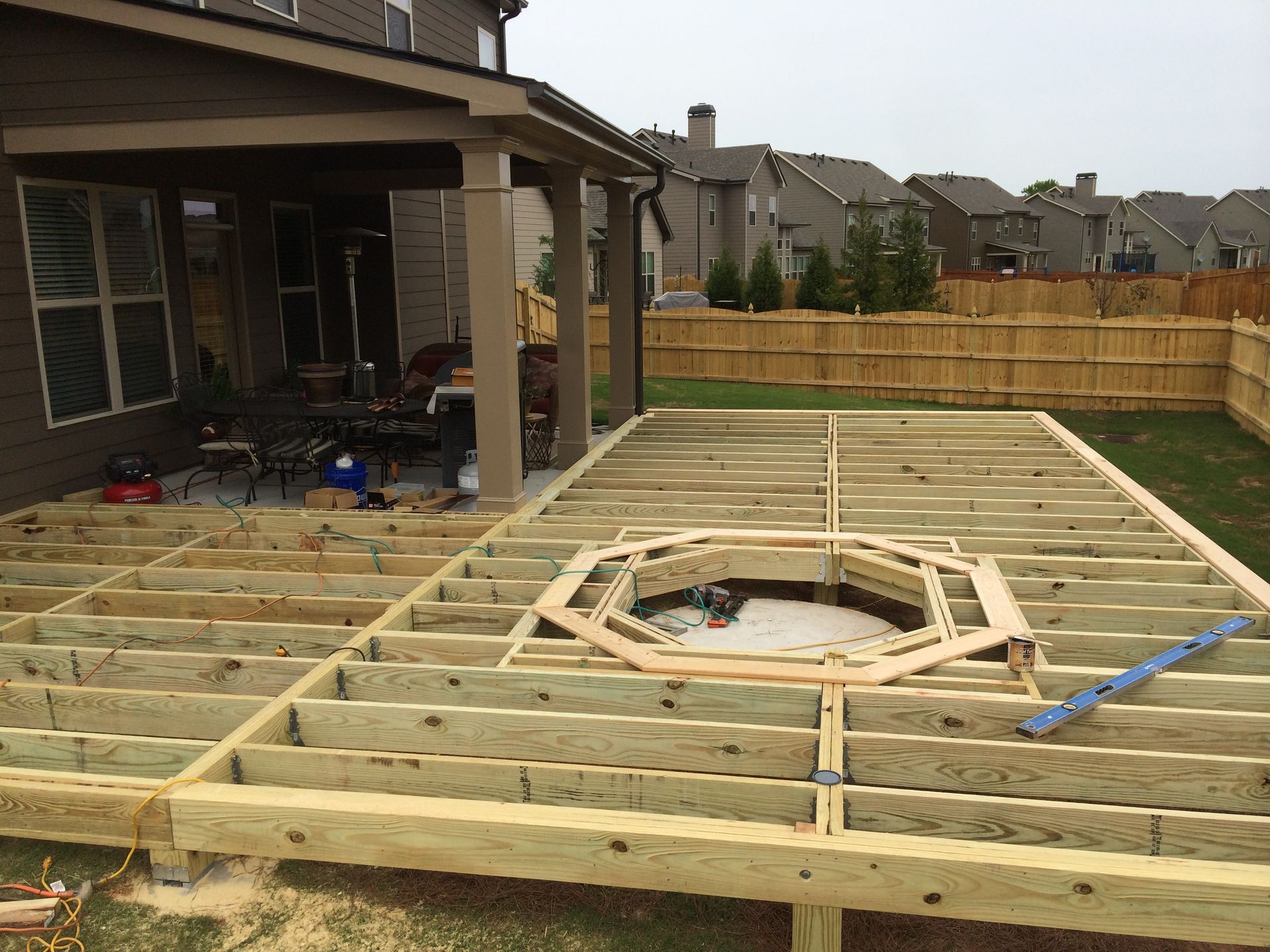 A wooden deck is being built in the backyard of a house.