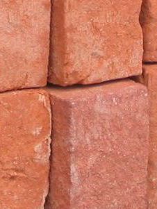 A close up of a pile of red bricks stacked on top of each other.