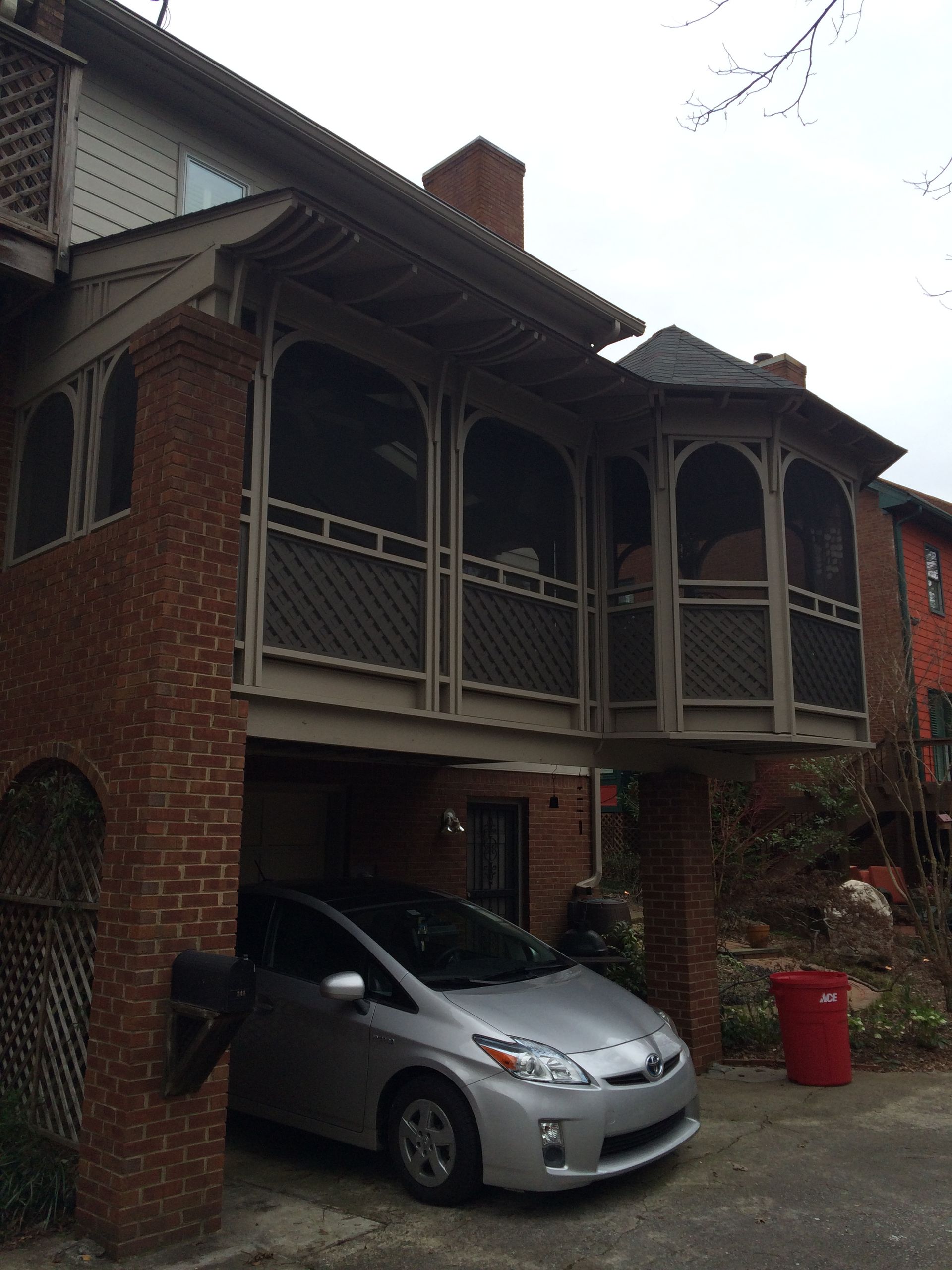 A silver car is parked in front of a brick building
