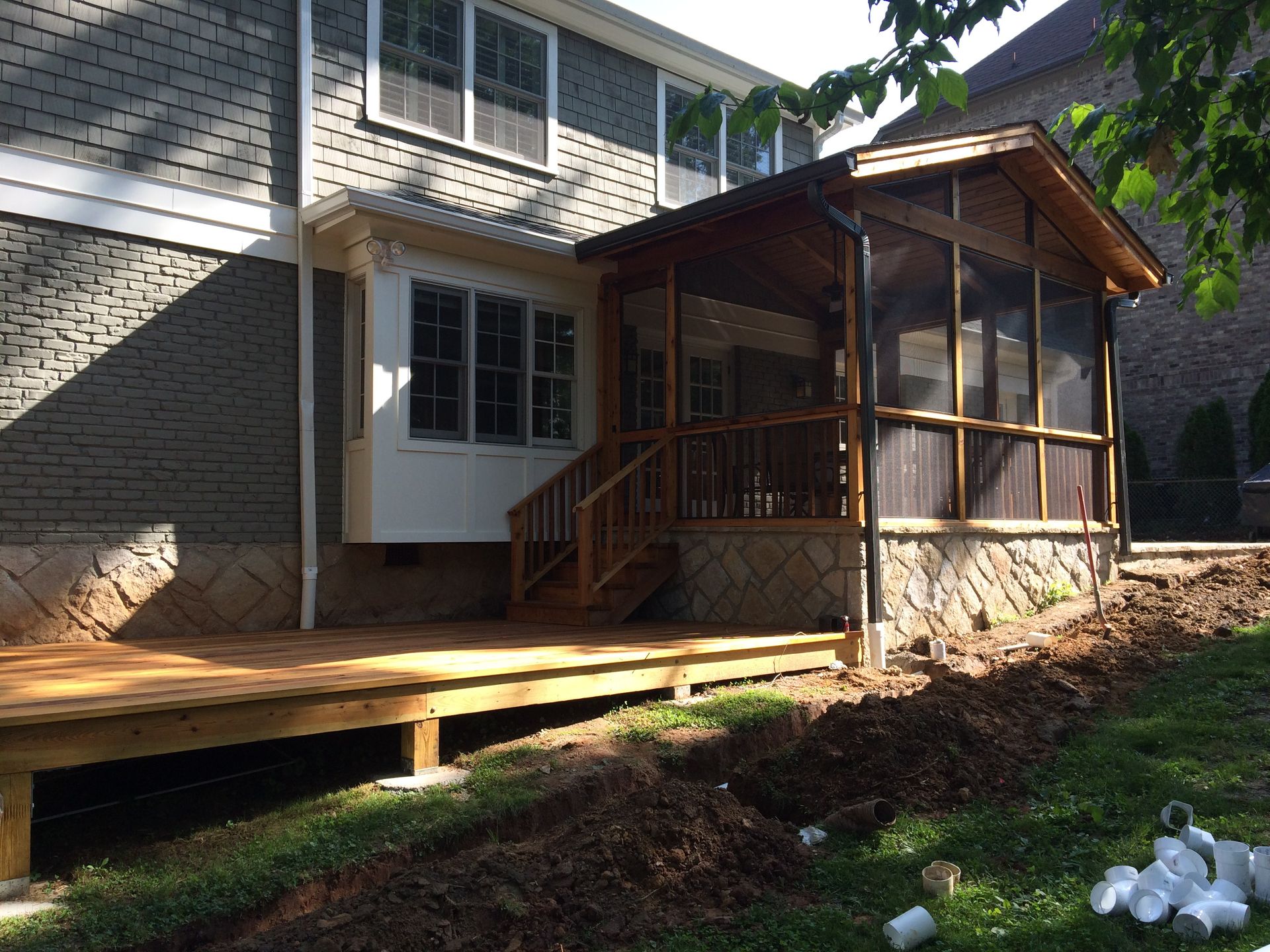 A screened in porch is being built on the side of a house.