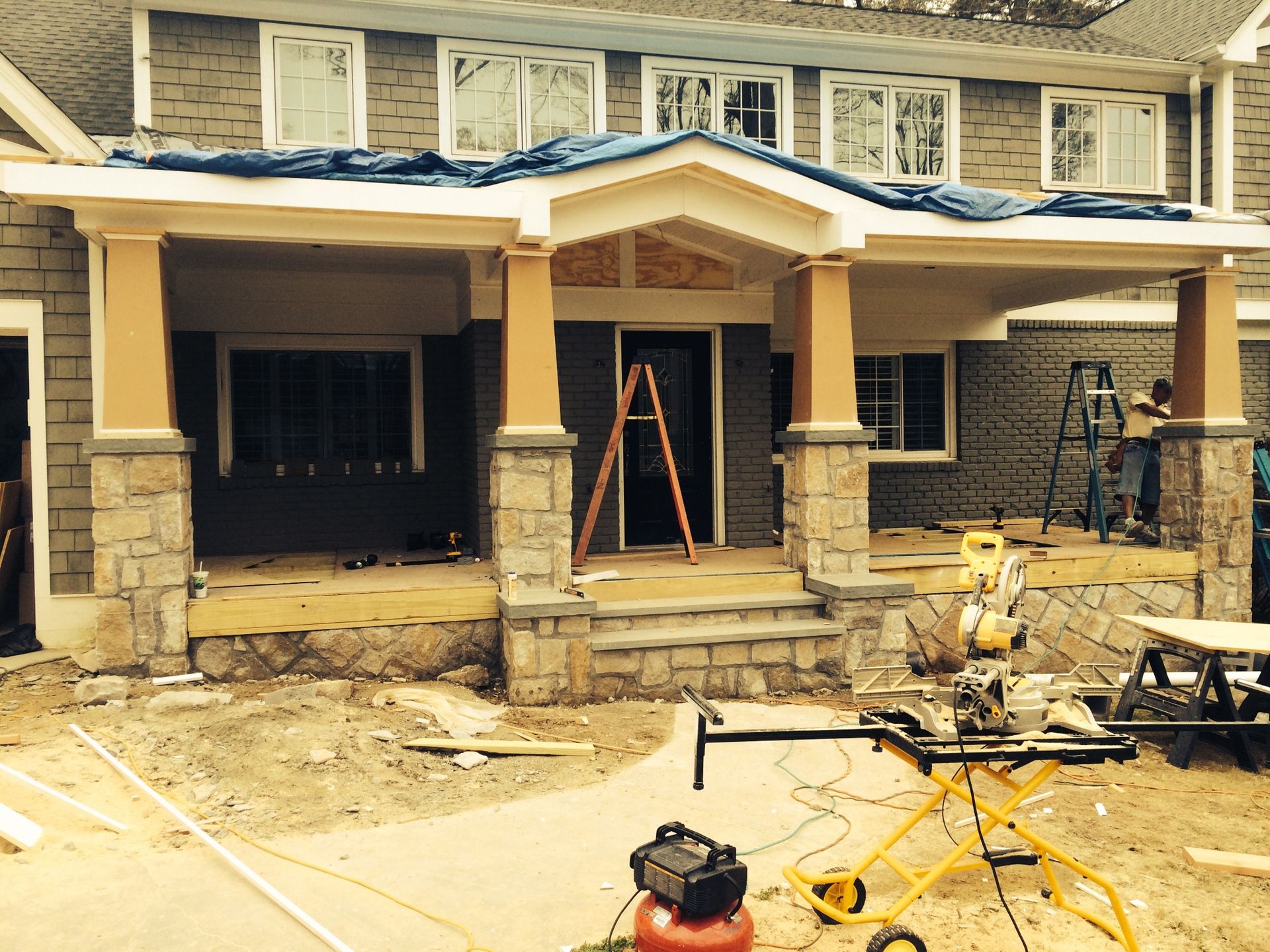 A house that is being remodeled with a yellow air compressor in front of it