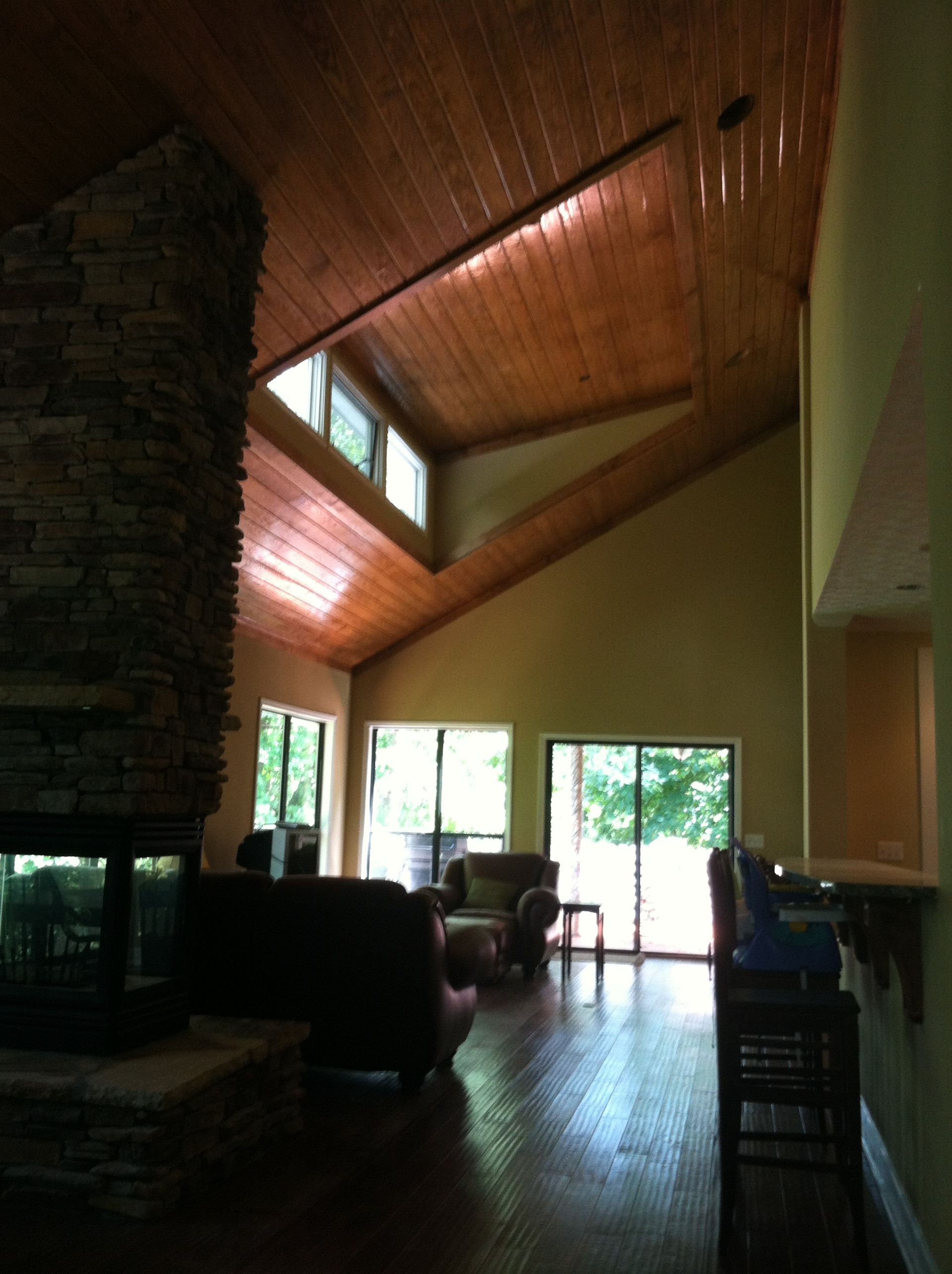 A living room with a vaulted ceiling and lots of windows