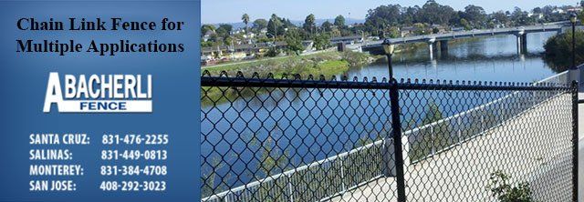 Chain link fence ad with a view of water, trees, and a bridge; company name and contact info included.