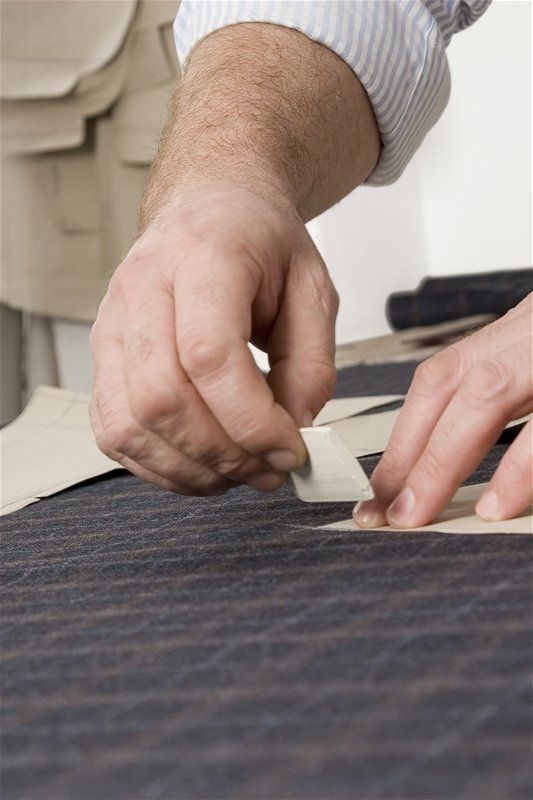 A person is measuring a piece of fabric with a tape measure