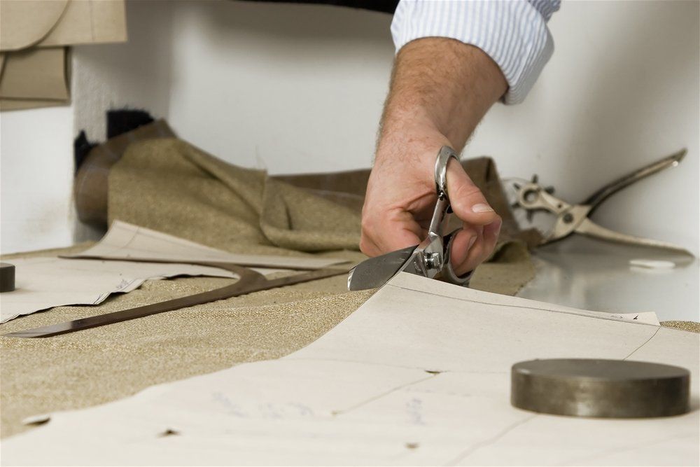 A person is cutting a piece of fabric with scissors
