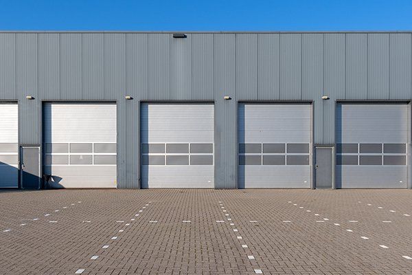 Row of Grey Industrial Units with Roller Shutter Doors — Hasbrouck Heights, NJ — Reiner Overhead Door Row of Grey Industrial Units with Roller Shutter Doors — Hasbrouck Heights, NJ — Reiner Overhead Door