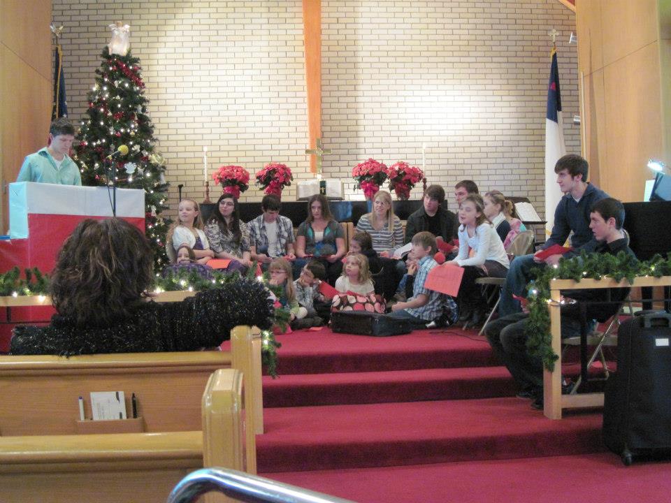 kids sitting in a church while practicing songs