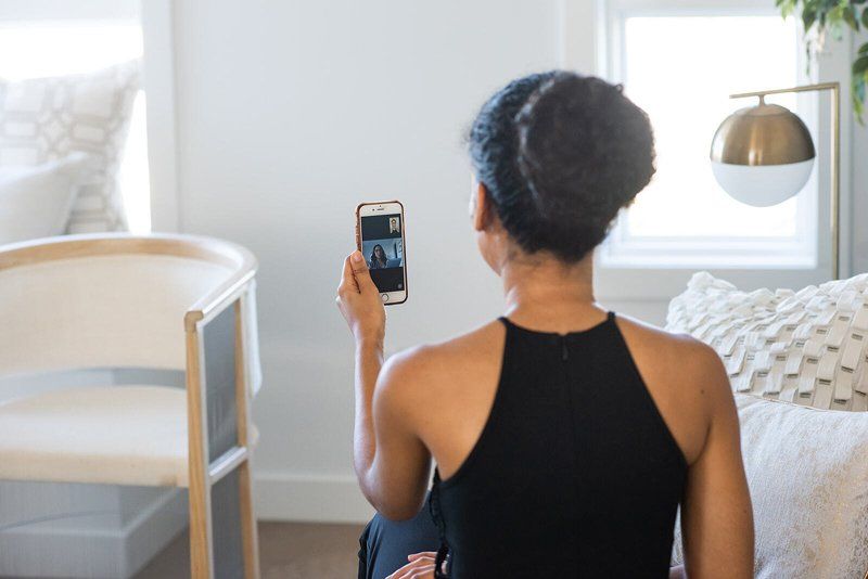 A woman is taking a picture of herself with her cell phone.