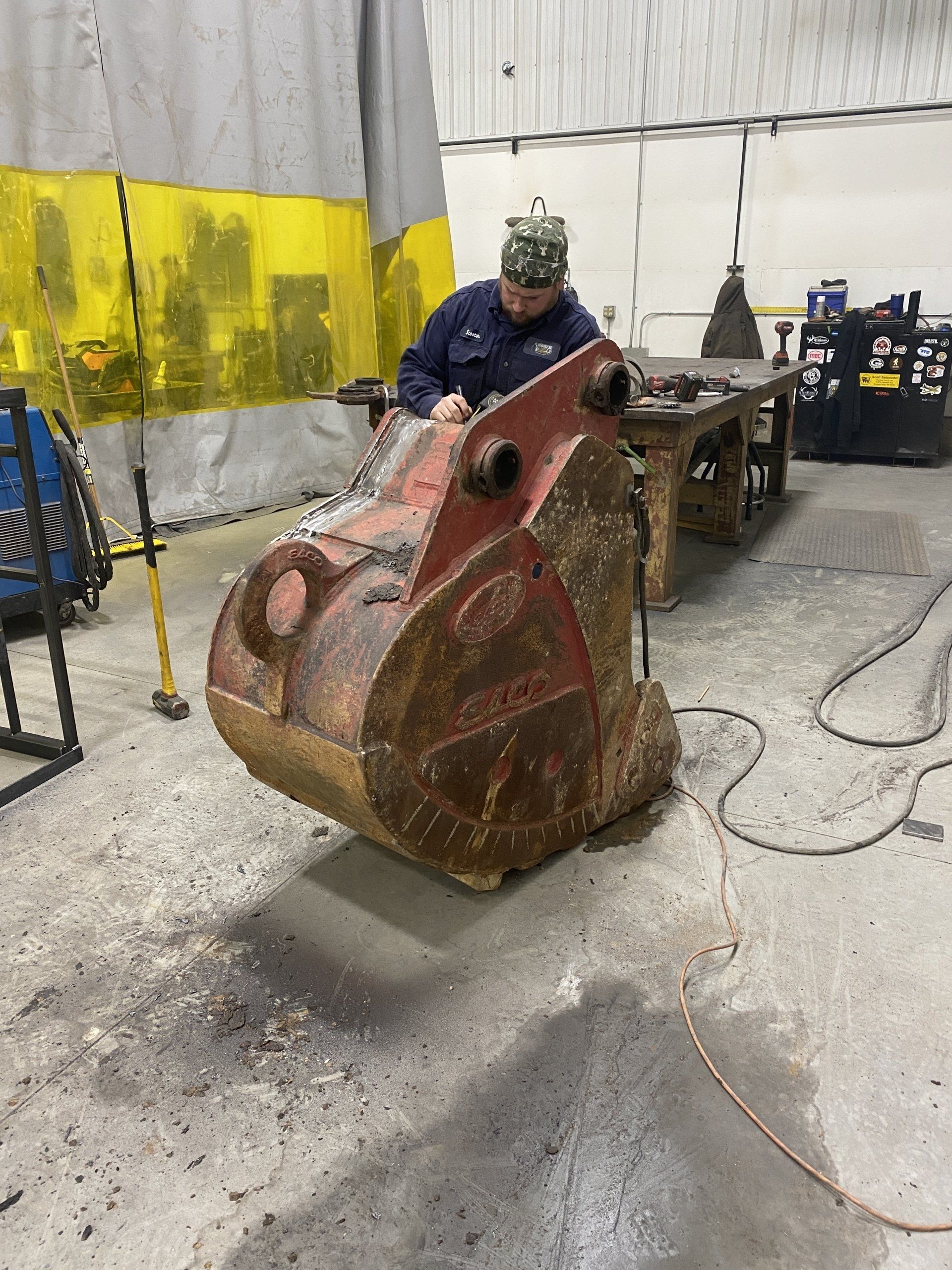 A man is working on a bucket in a garage.