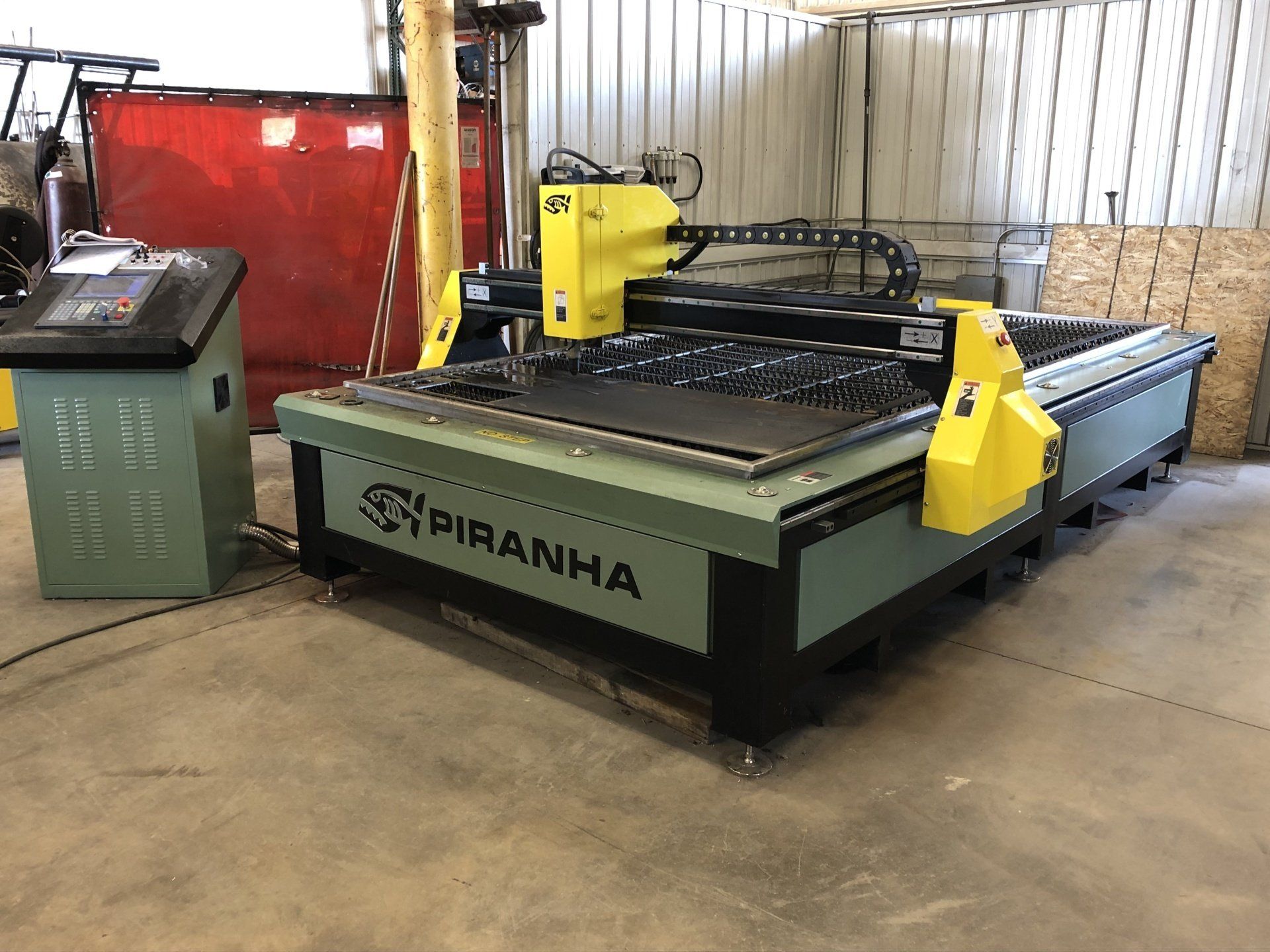 A piranha cutting machine is sitting in a warehouse.