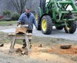 Trimming log with saw.