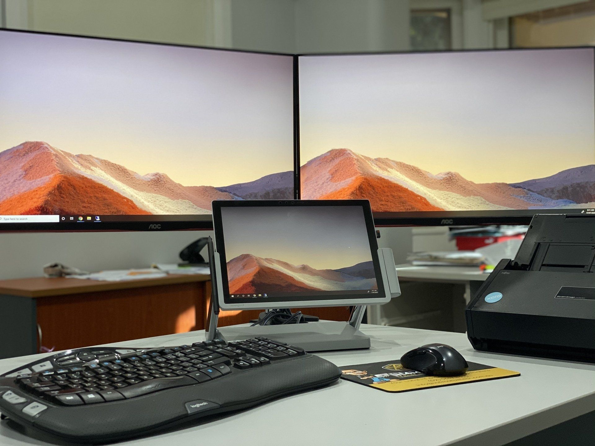 A desk with two monitors and a keyboard and mouse