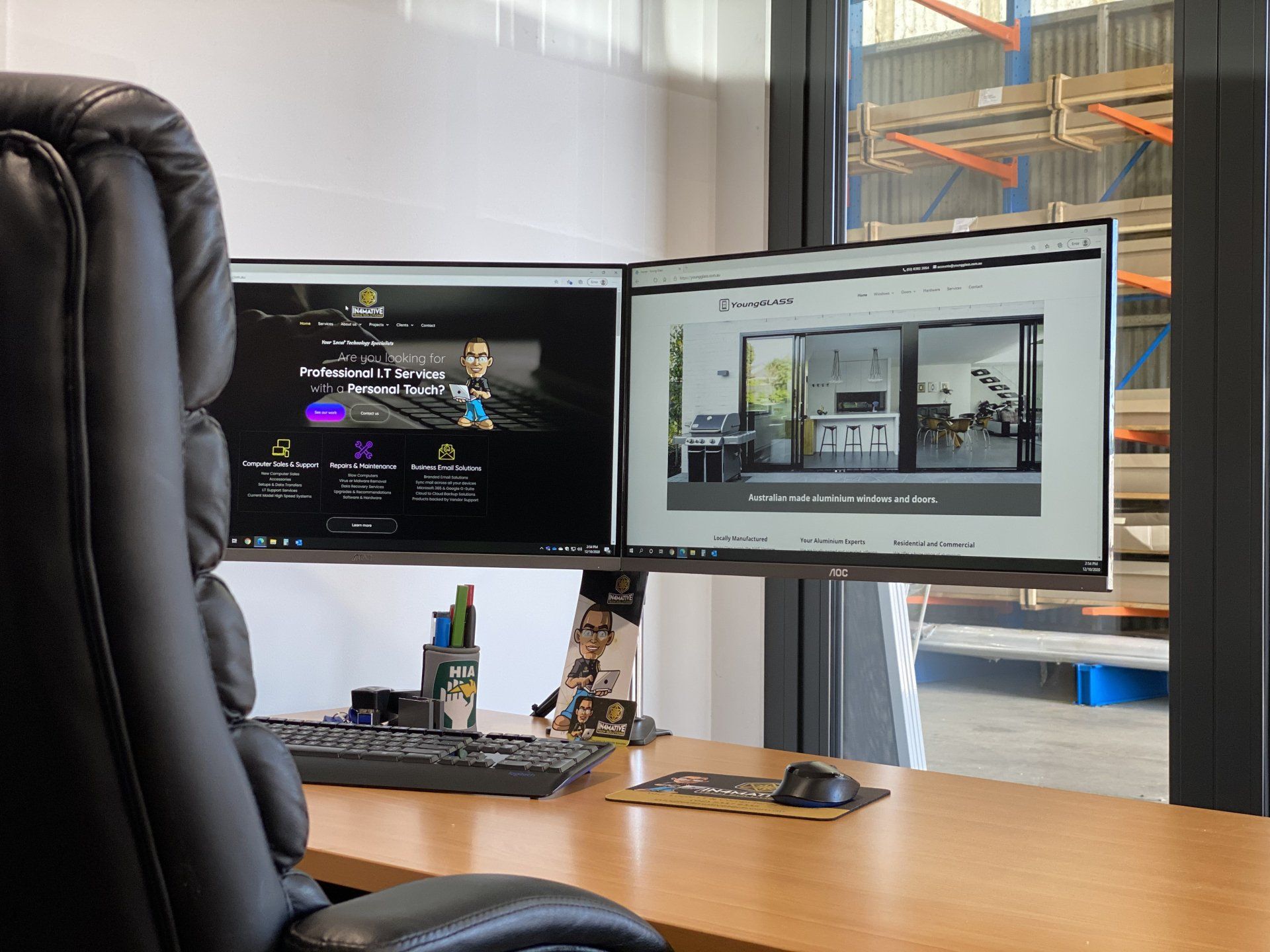 A desk with two computer monitors on it and a chair.