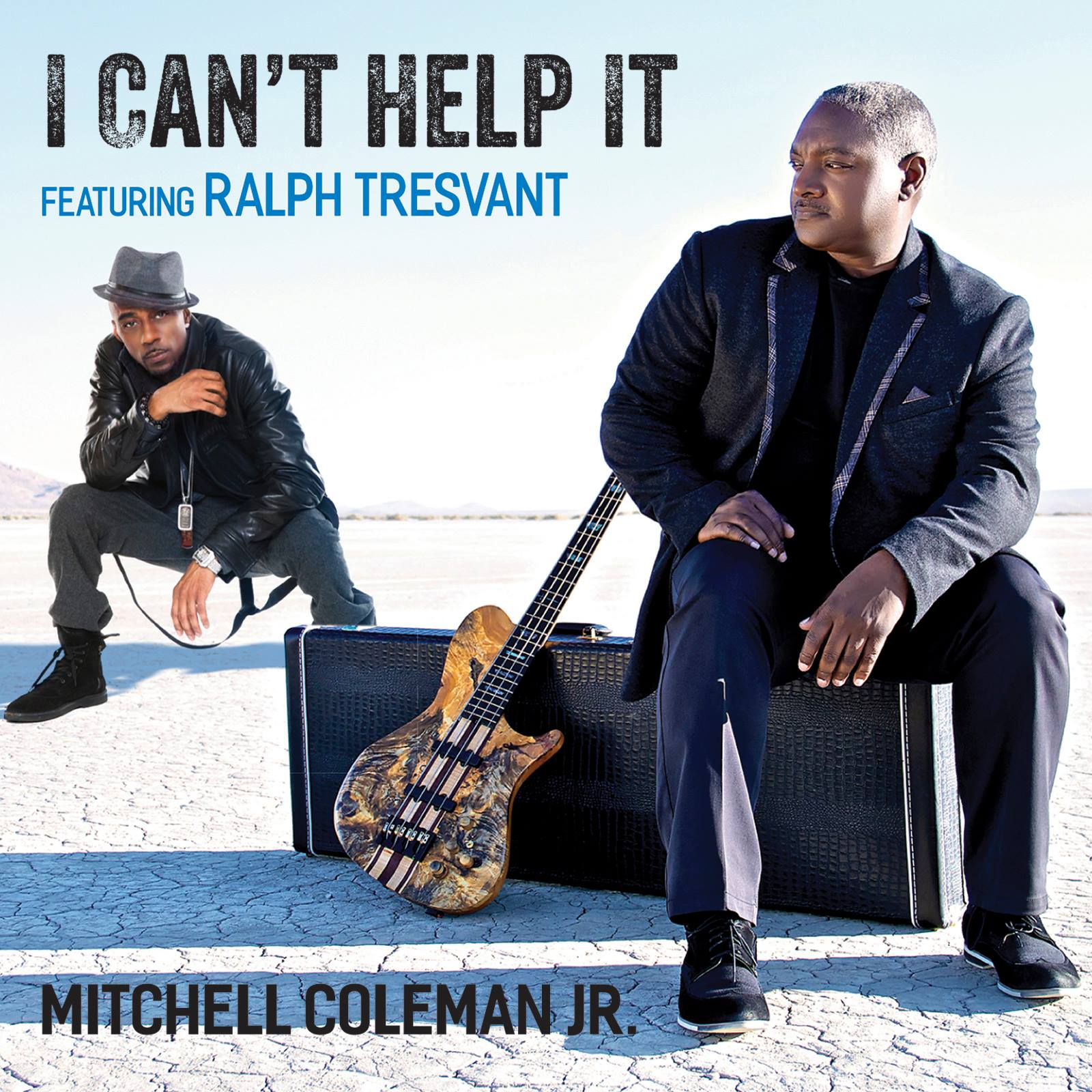 Album cover featuring two men in dark clothes with a guitar leaning on a case, titled “I Can’t Help It.”