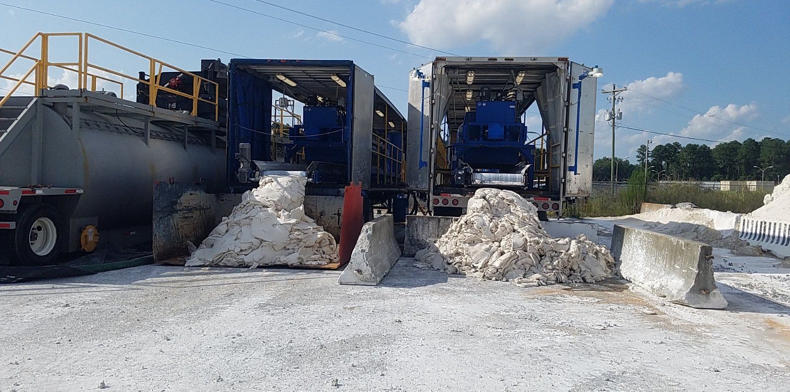 Two trucks are parked next to each other in a field filled with foam.