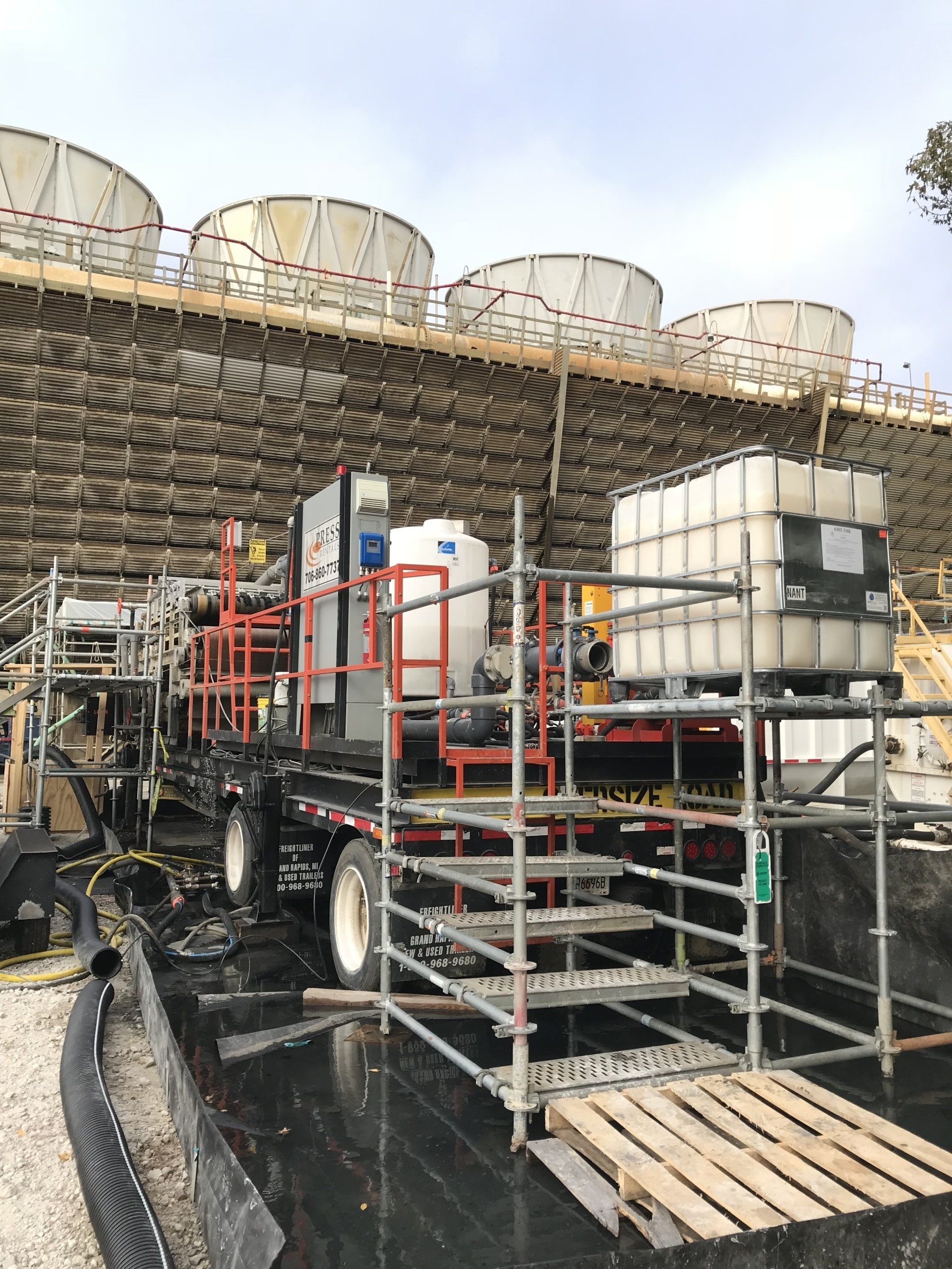 A truck is parked in front of a building with scaffolding around it.