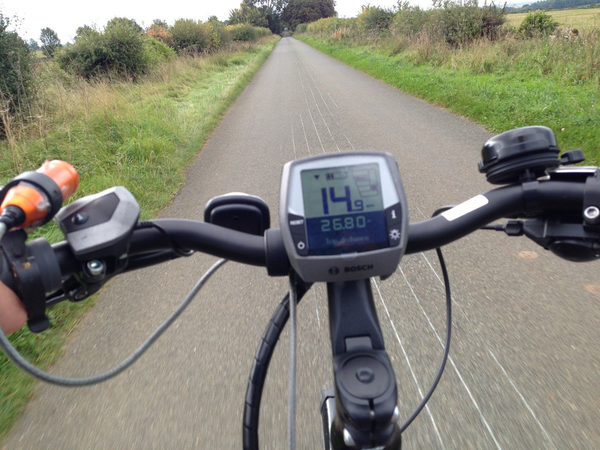 A person is riding a bike down a road with a speedometer reading 14.6