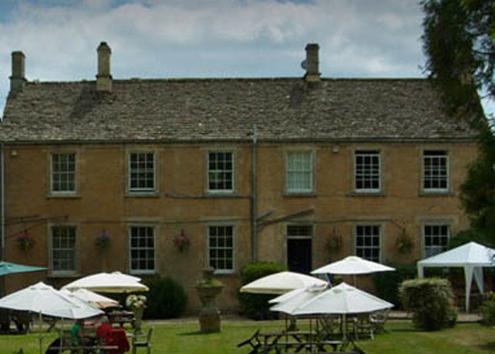 A large building with tables and umbrellas in front of it
