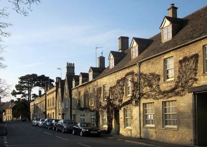 A row of buildings with cars parked in front of them