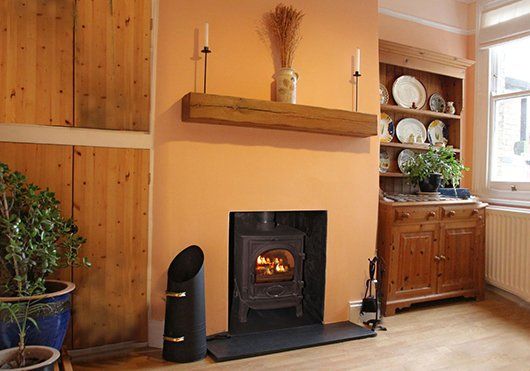 Wood burning stove in a cosy room with wooden furniture and decor