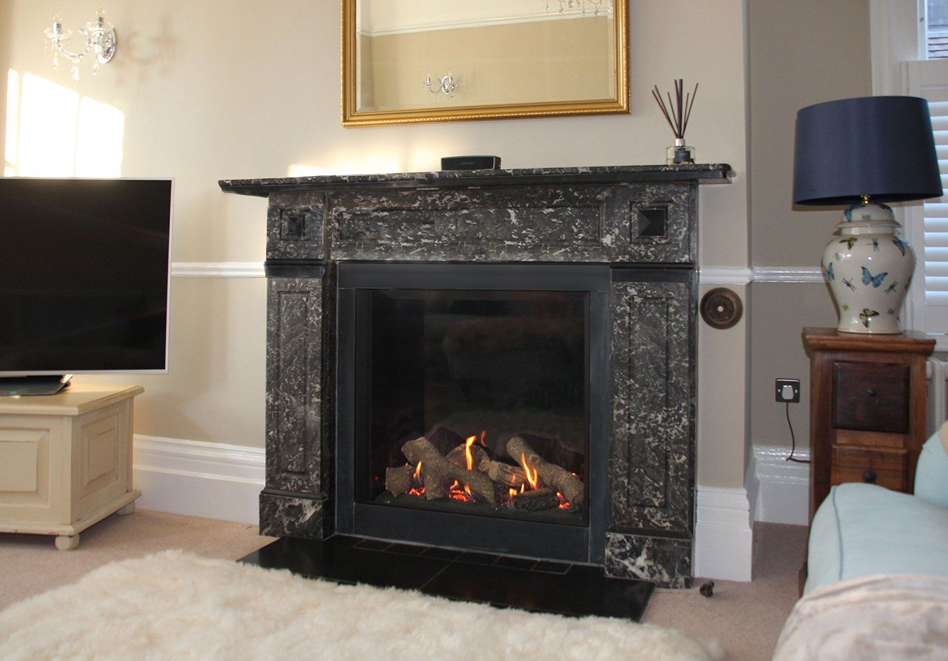 Modern gas fireplace with dark marble surround in a stylish living room