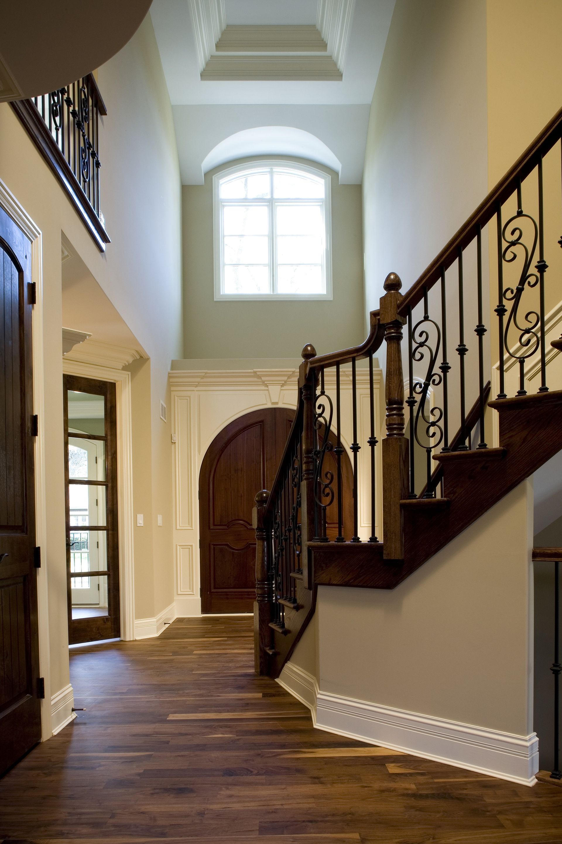 A hallway with a staircase and a window