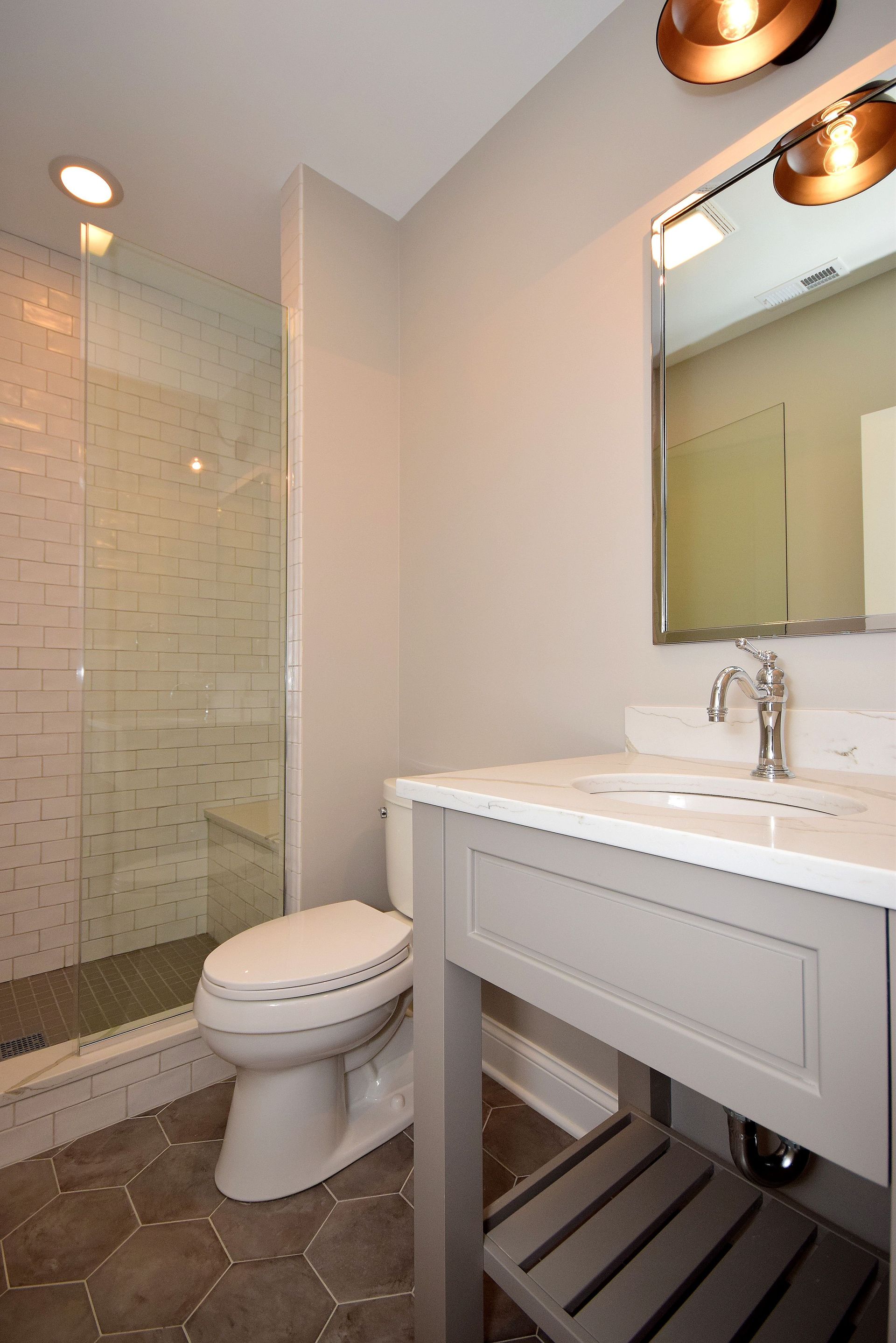 A bathroom with a toilet , sink and shower.