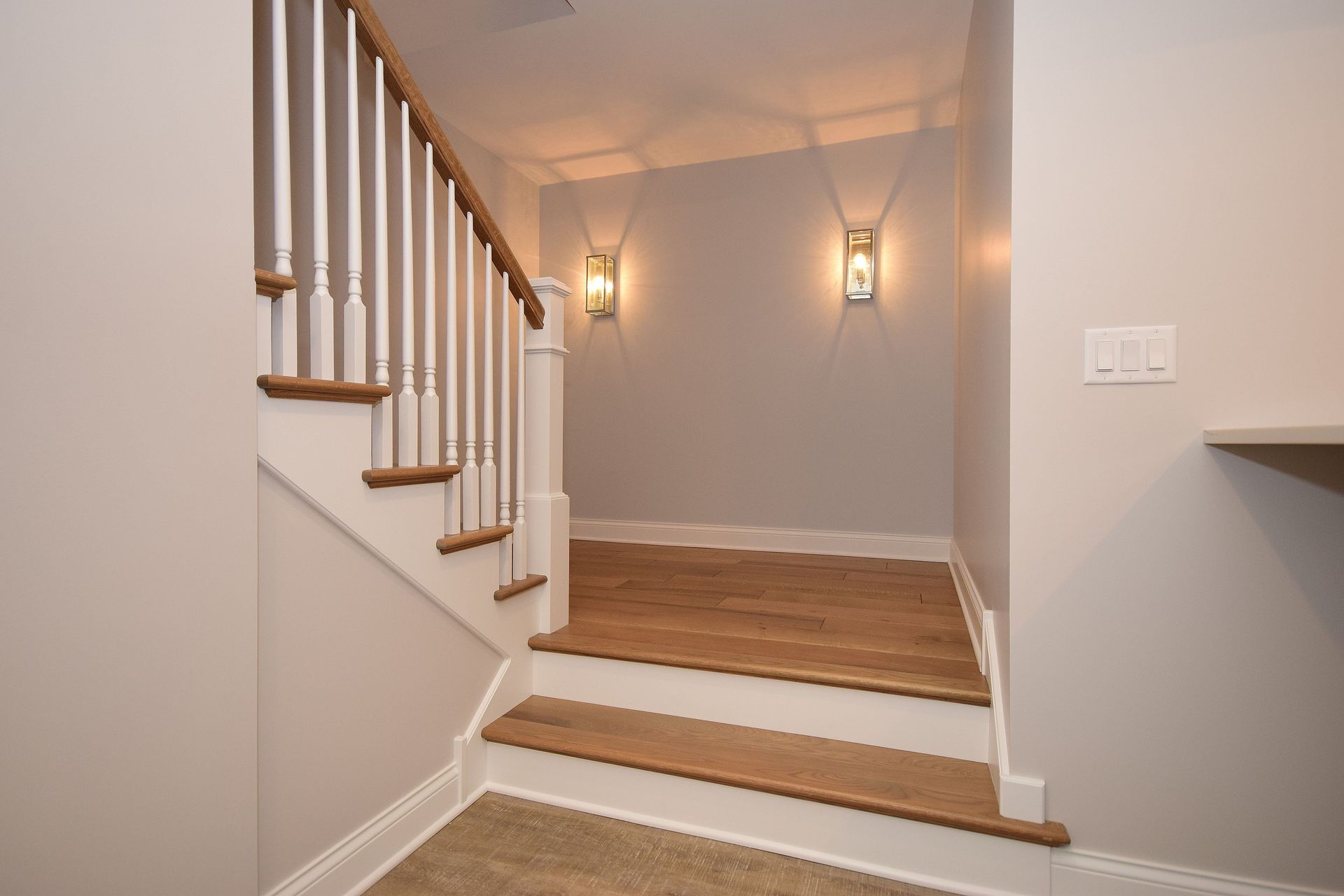 A staircase in a house with wooden steps and a white railing