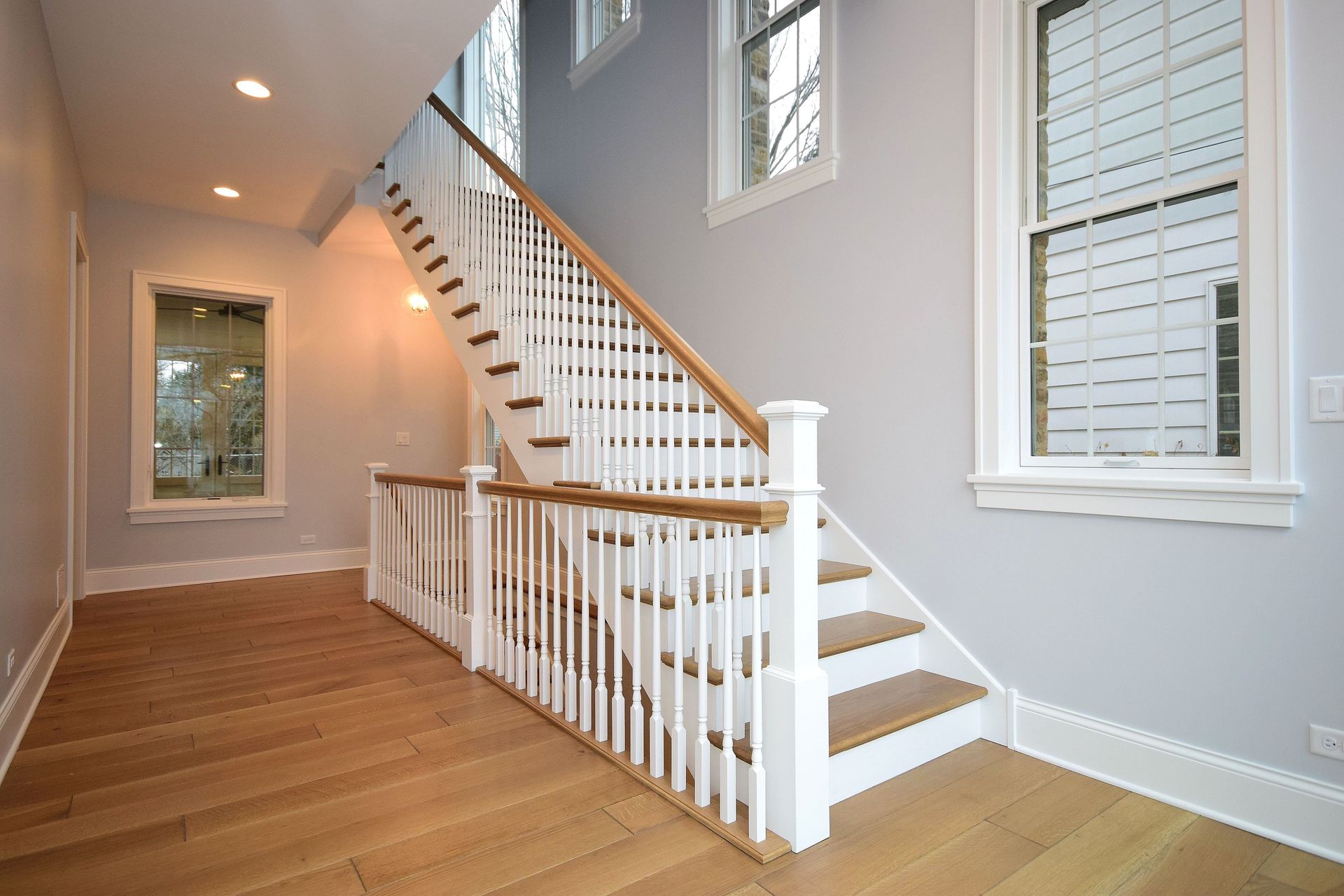 A staircase with a white railing and wooden steps in a hallway.