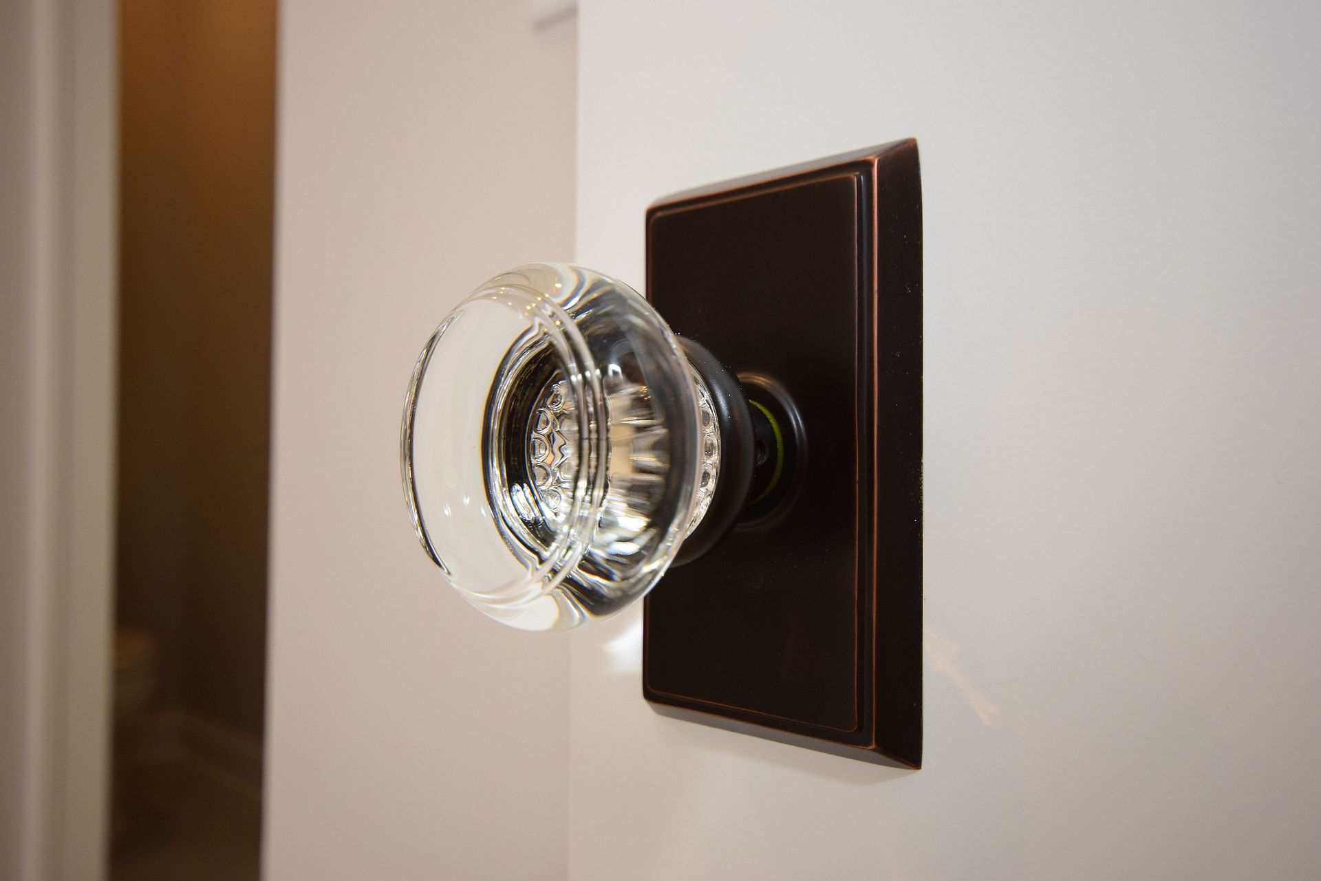A close up of a glass door knob on a door.