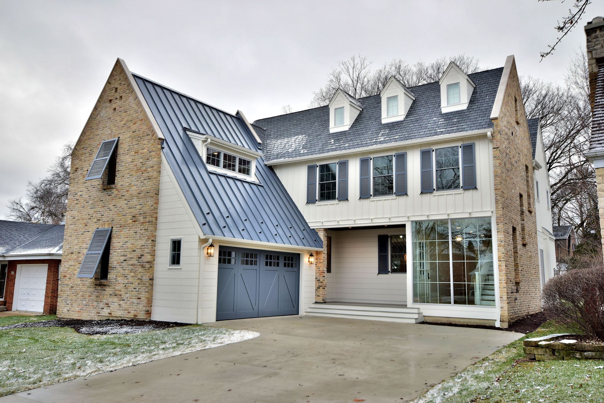 A large white house with a blue roof and a garage