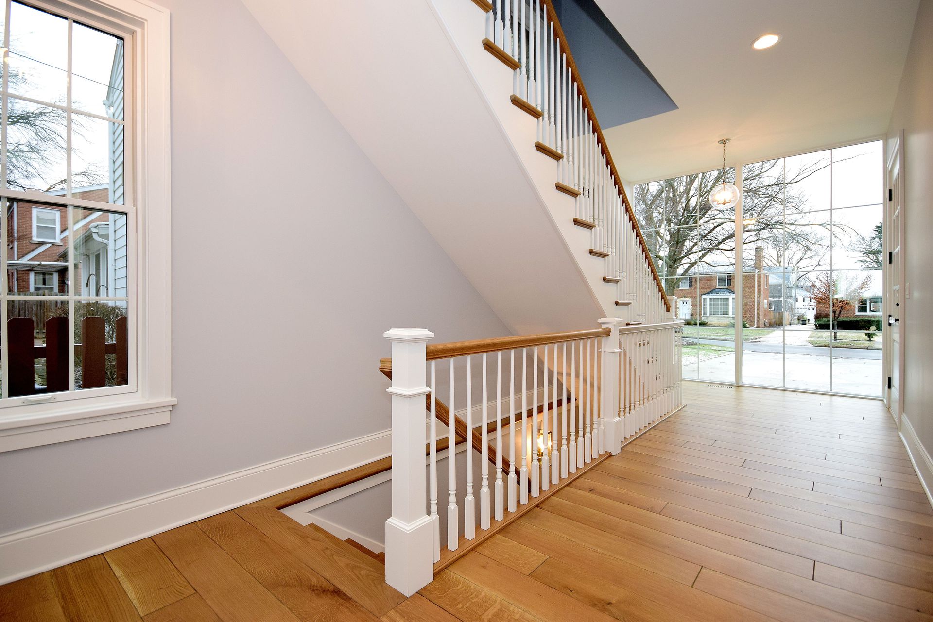 An empty hallway with a staircase and a window