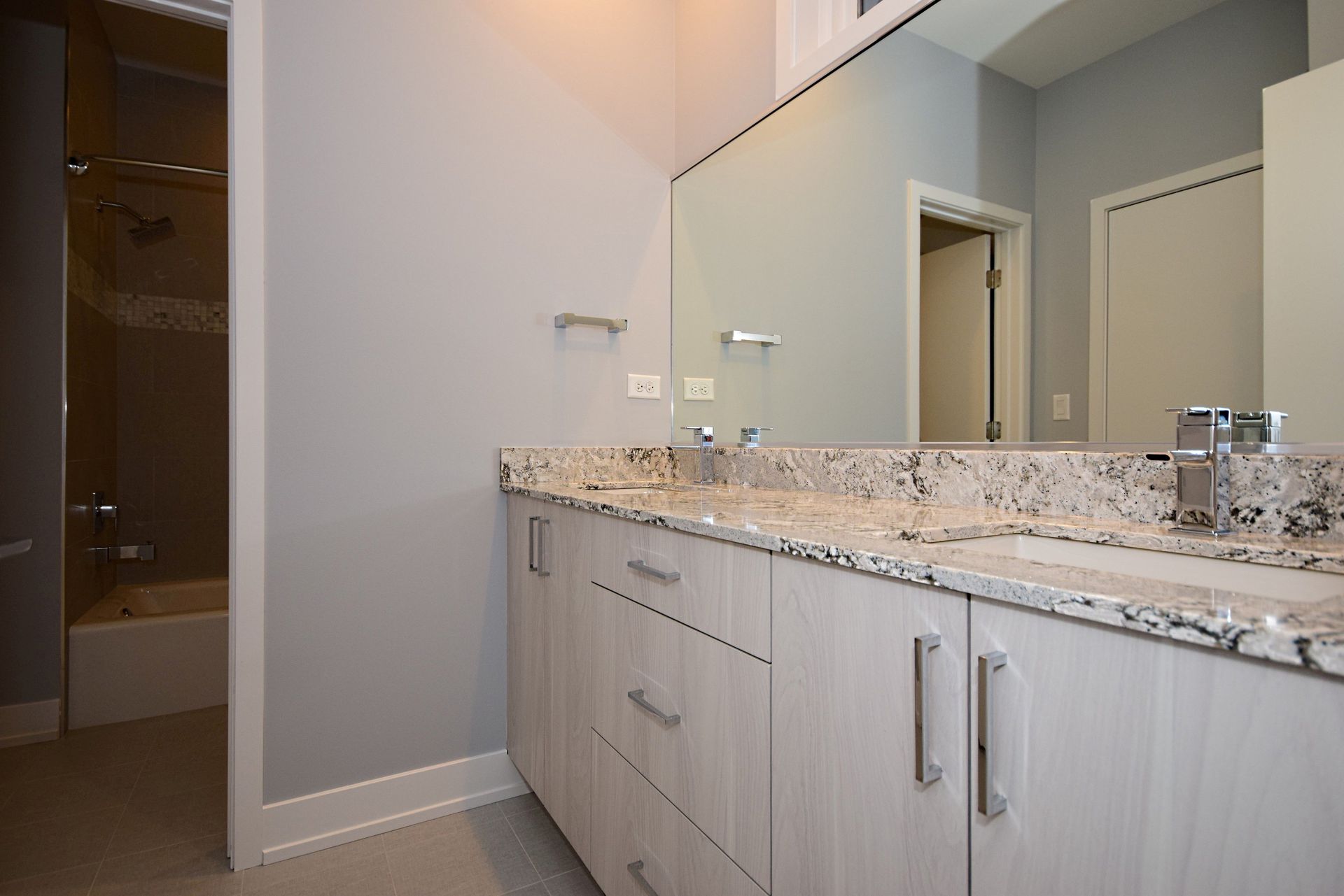 A bathroom with two sinks and a large mirror.