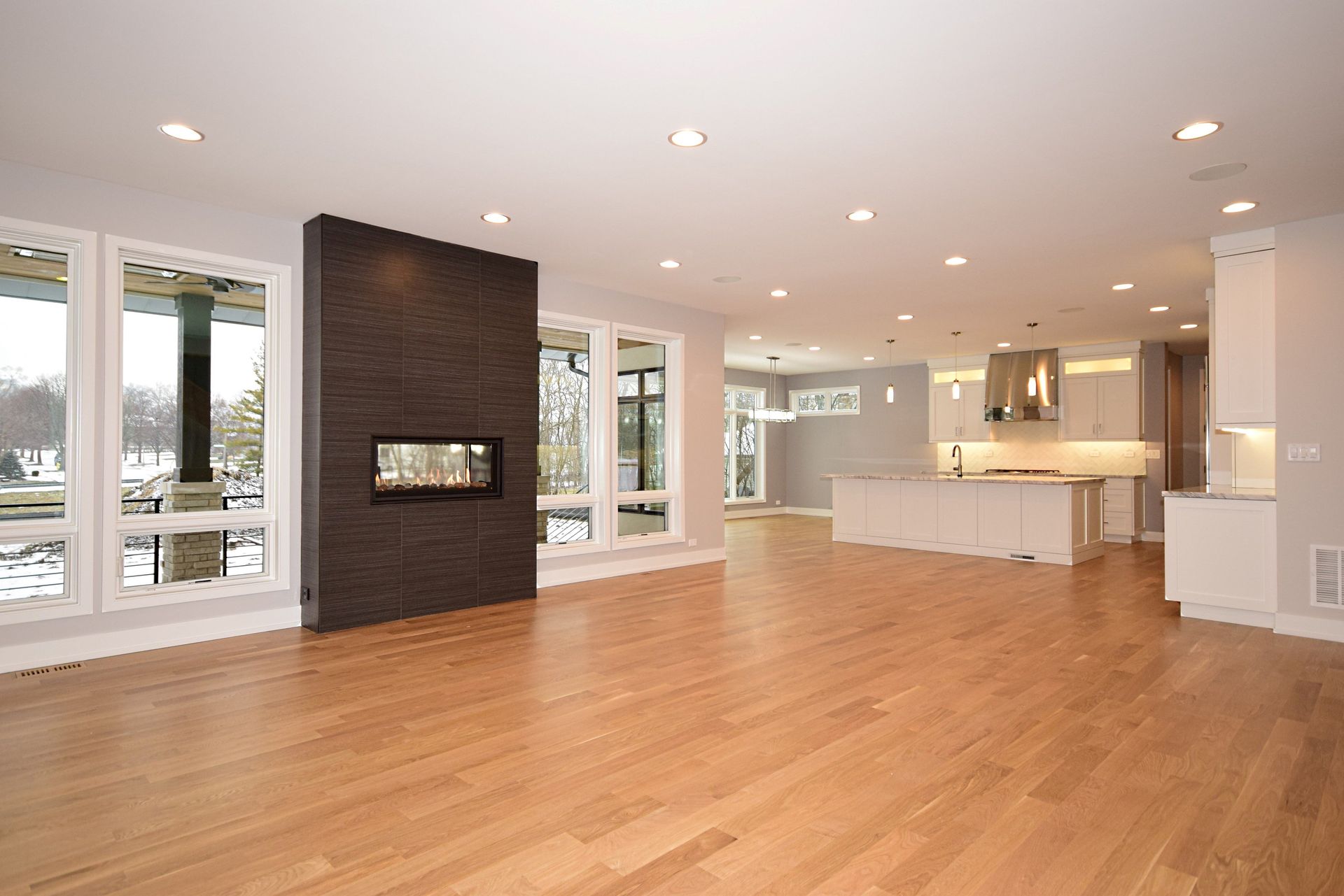 An empty living room with hardwood floors and a fireplace.