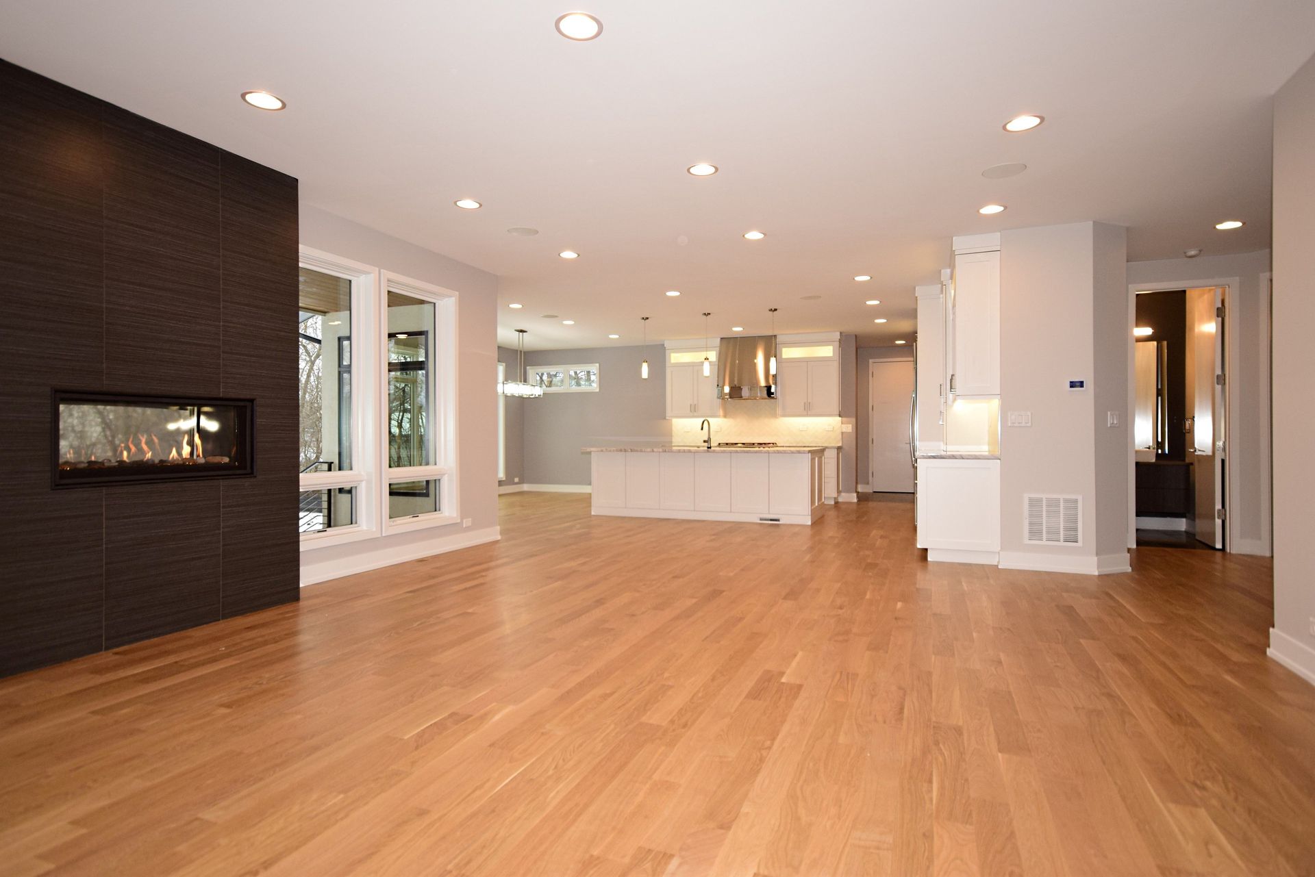An empty living room with hardwood floors and a fireplace.