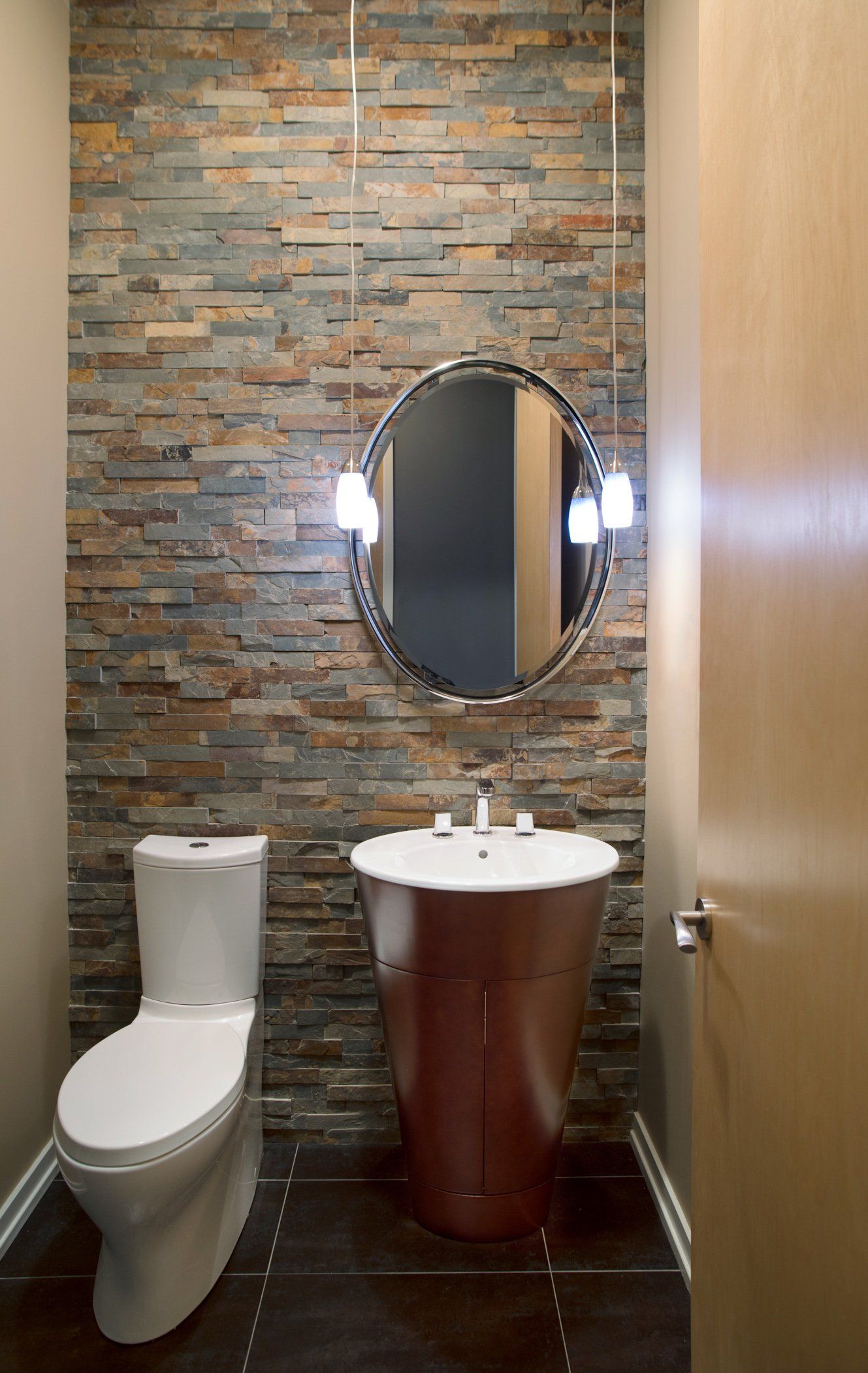 A bathroom with a toilet , sink and mirror.