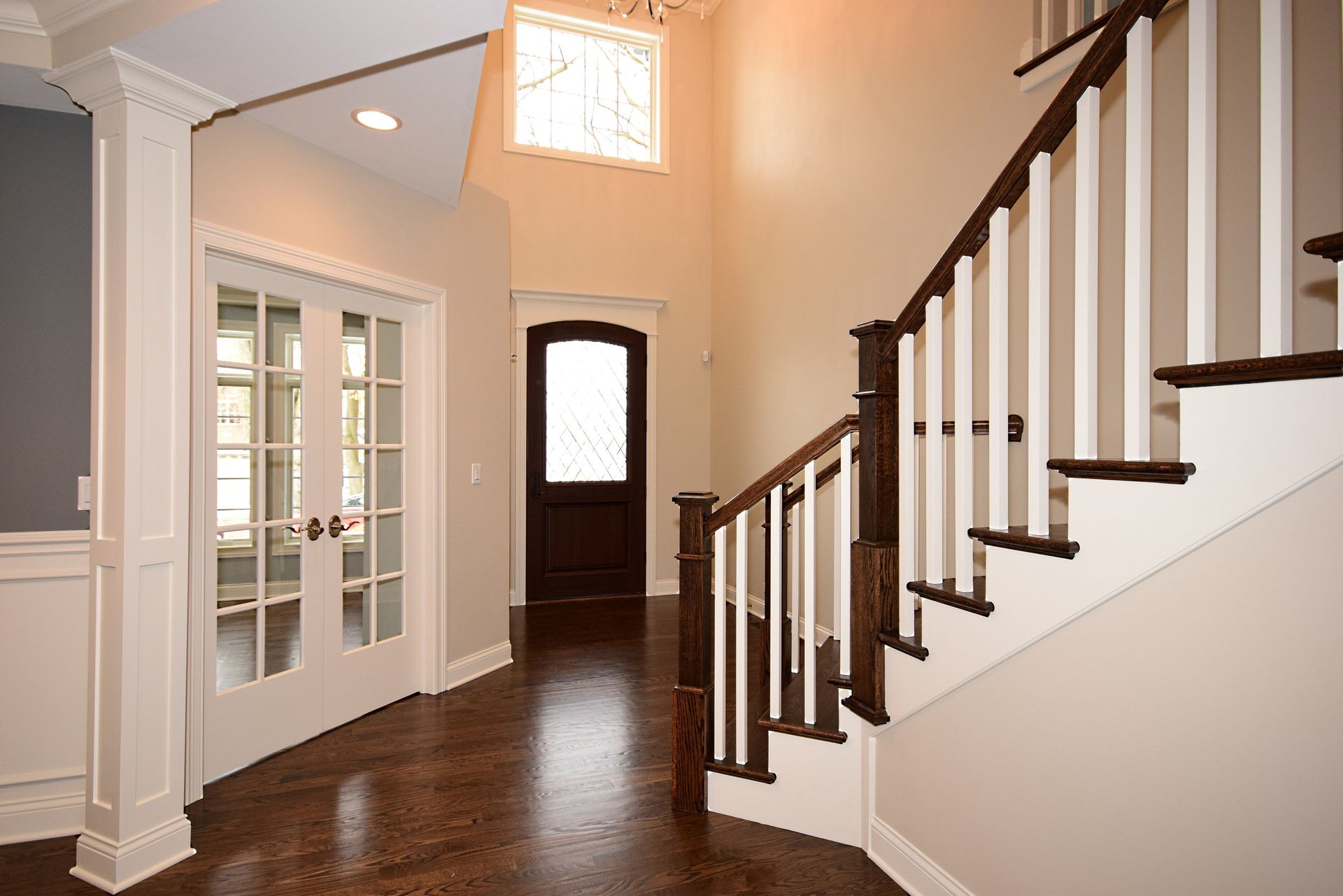 A hallway with a staircase and a door in a house.