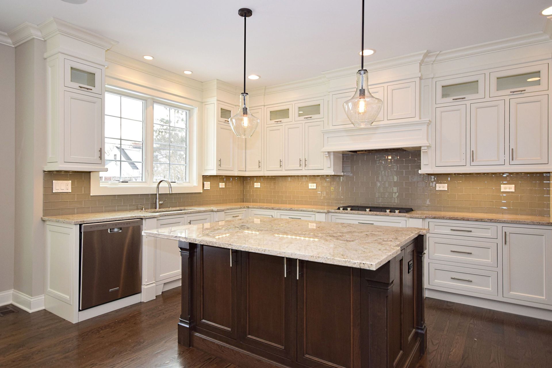A kitchen with white cabinets and a large island in the middle.