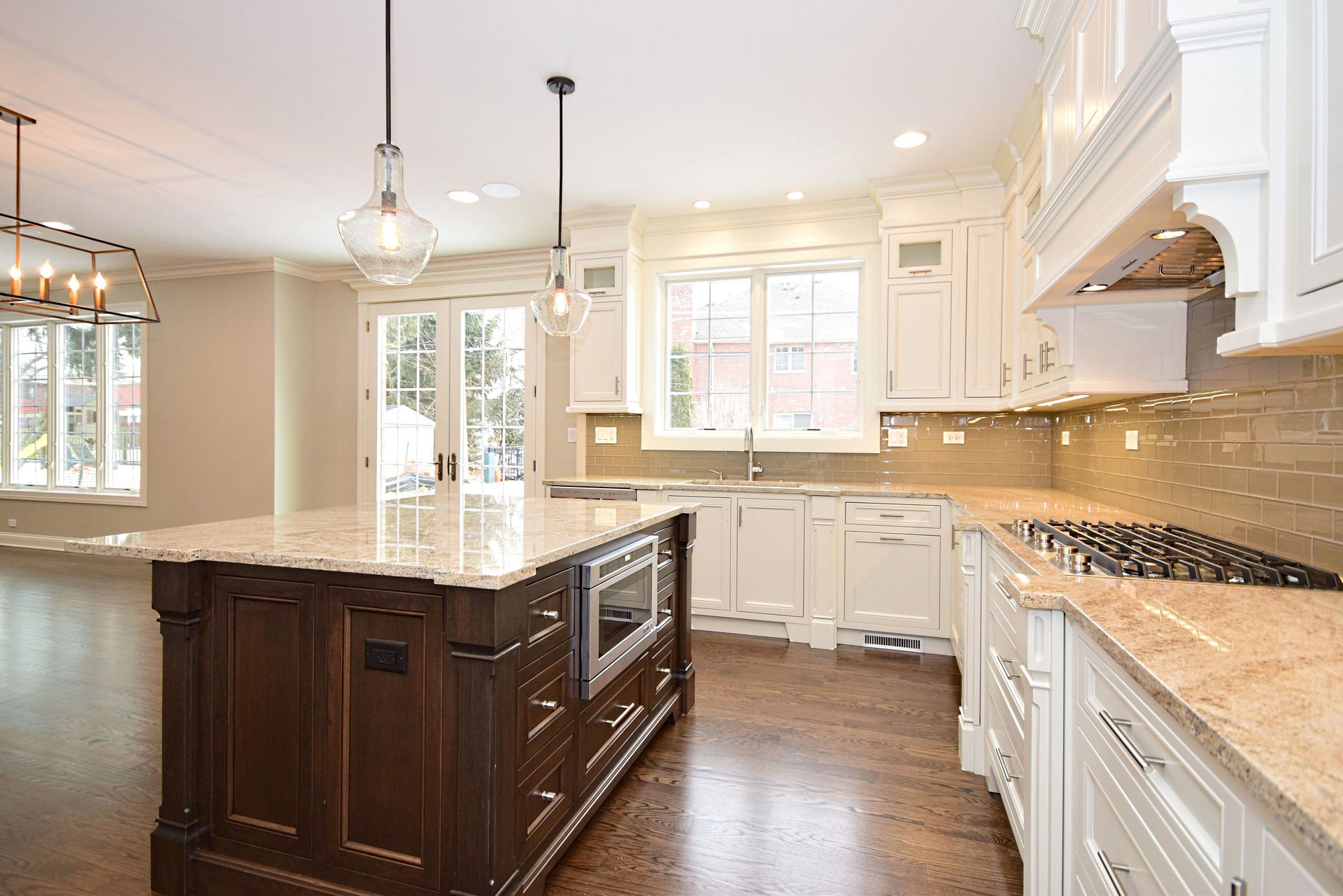 A kitchen with white cabinets , granite counter tops , and a large island.
