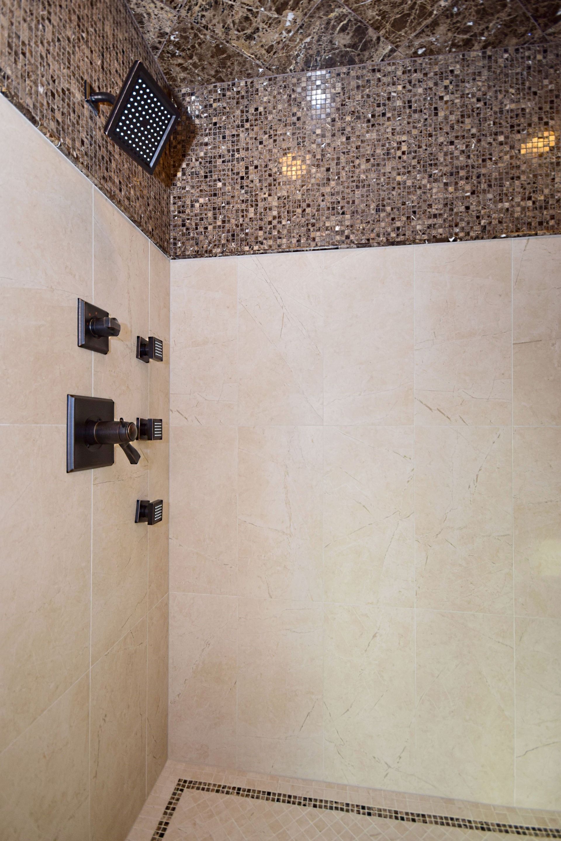 A shower with a marble ceiling and a shower head