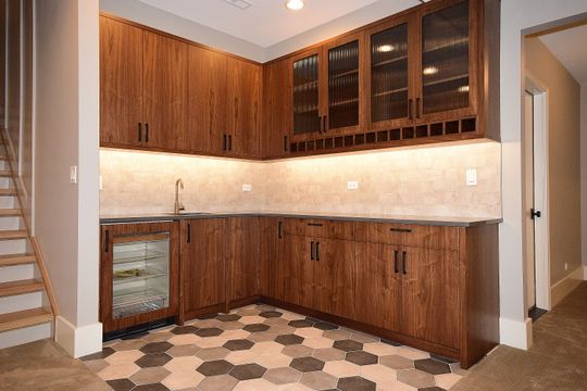 A kitchen with wooden cabinets and a tiled floor