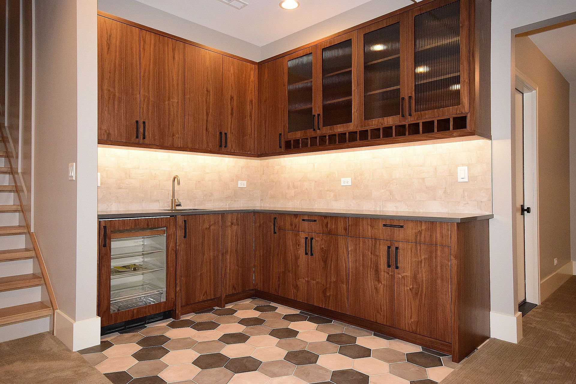 A kitchen with wooden cabinets and a tiled floor