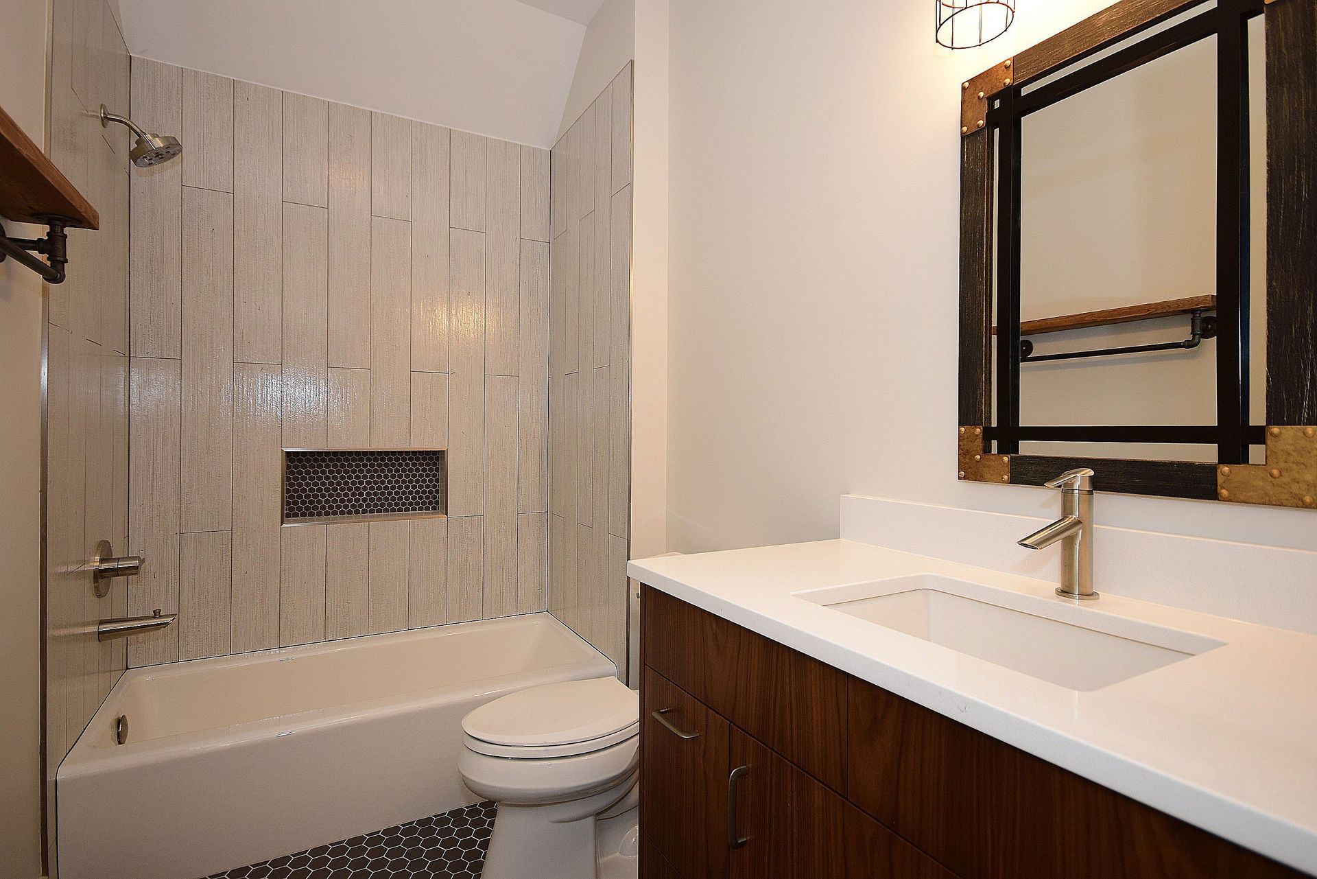 A bathroom with a sink , toilet , bathtub and mirror.