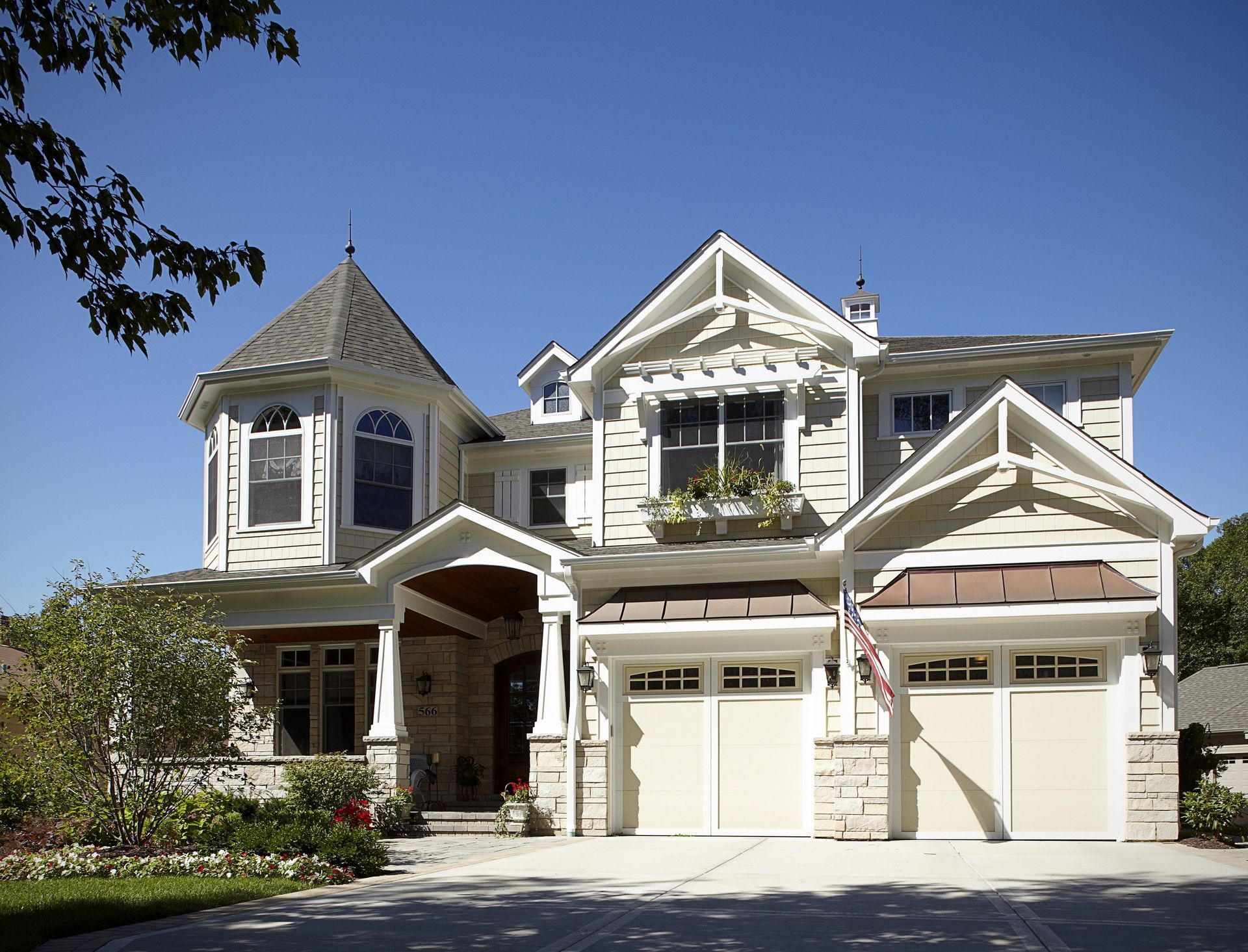 A large house with two garage doors and a tower on top
